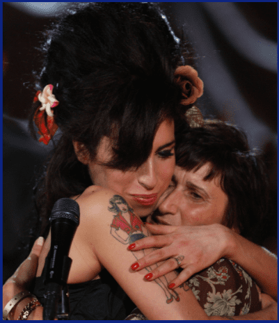Die britische Sängerin Amy Winehouse (L) umarmt ihre Mutter Janis Winehouse, nachdem sie am 10. Februar 2008 in London, England, per Videolink einen Grammy Award in den Riverside Studios für die 50. | Quelle: Getty Images