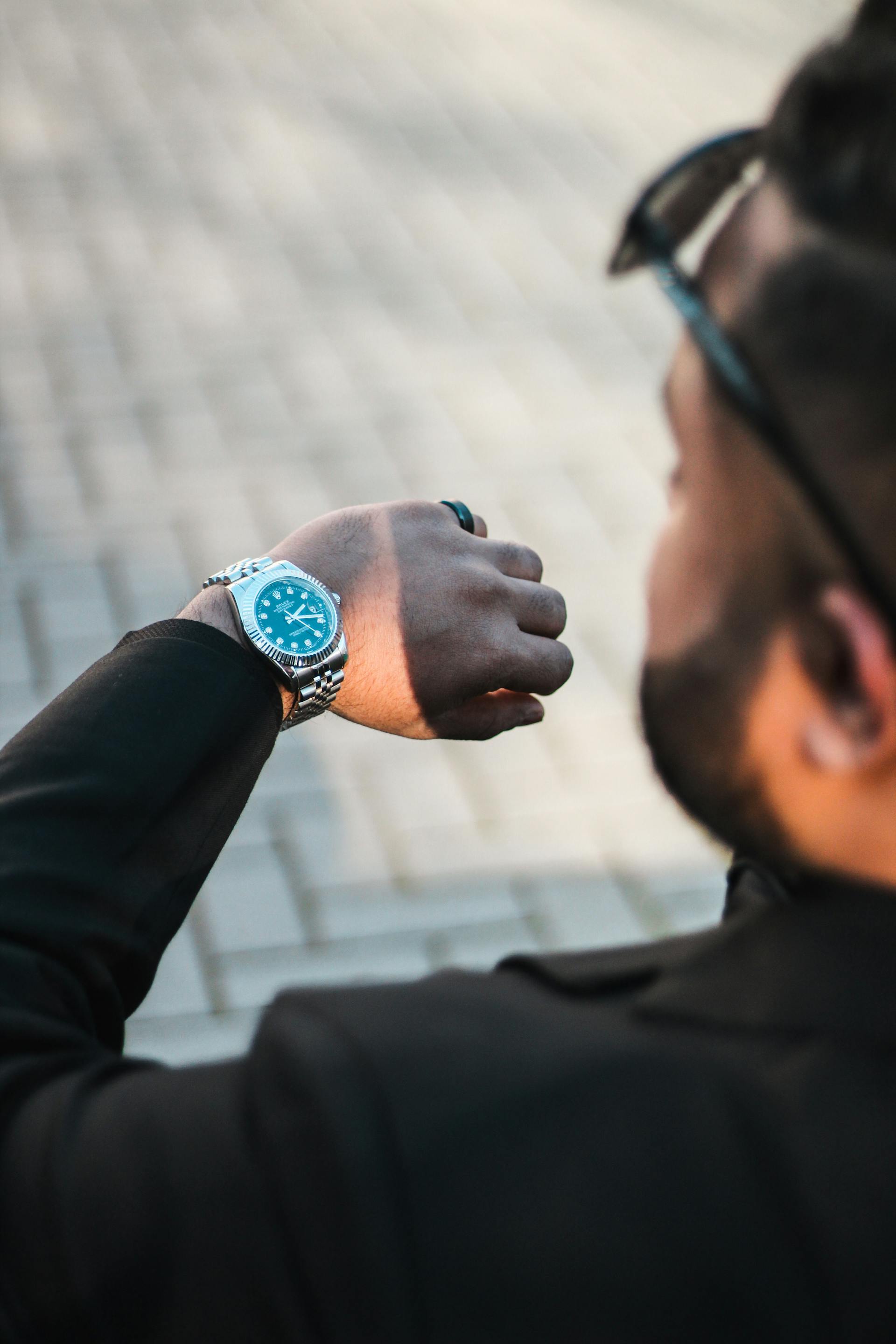 Ein Mann überprüft seine Uhr | Quelle: Pexels