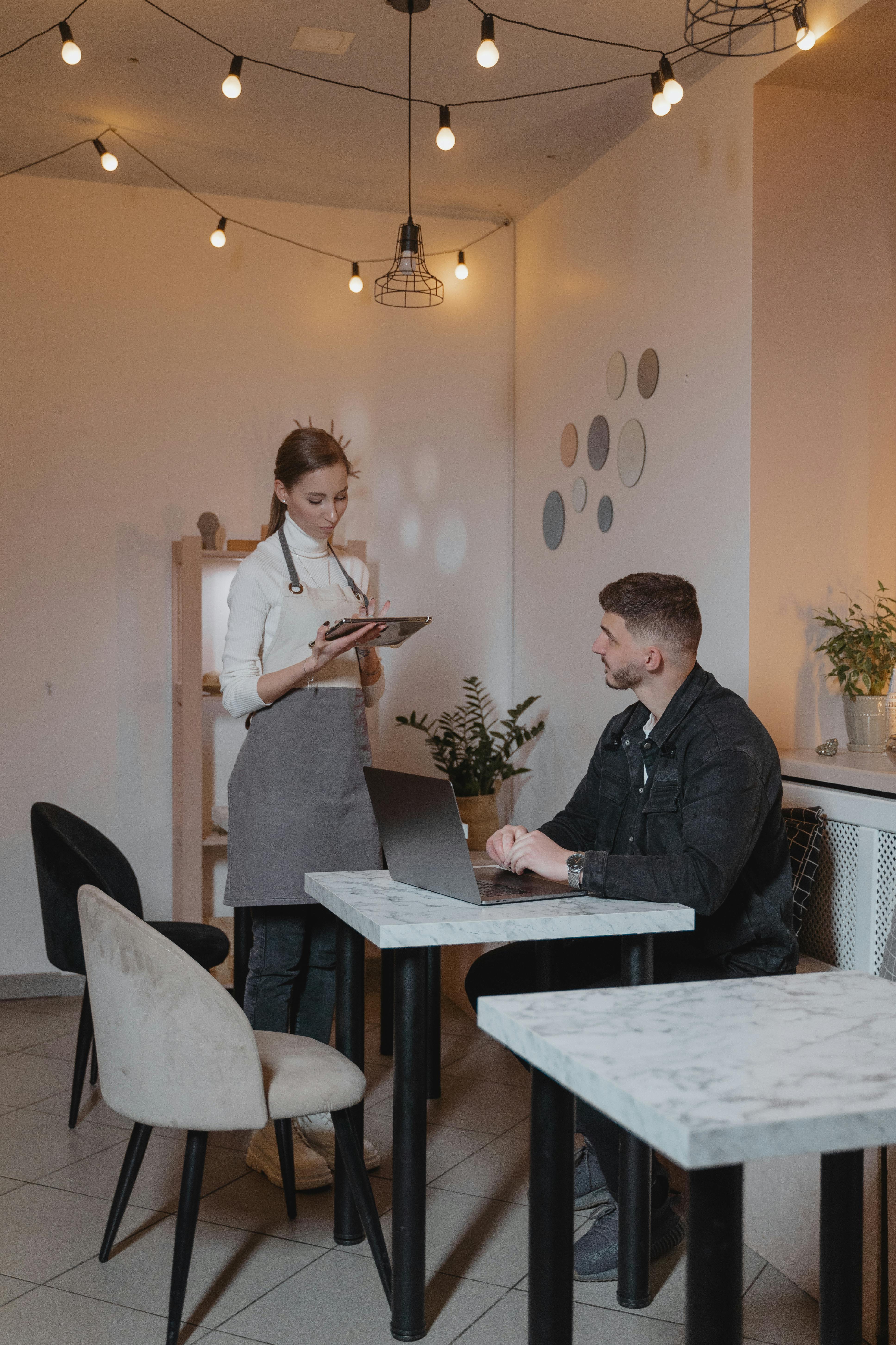 Kellnerin im Gespräch mit einem Kunden in einem Restaurant | Quelle: Pexels