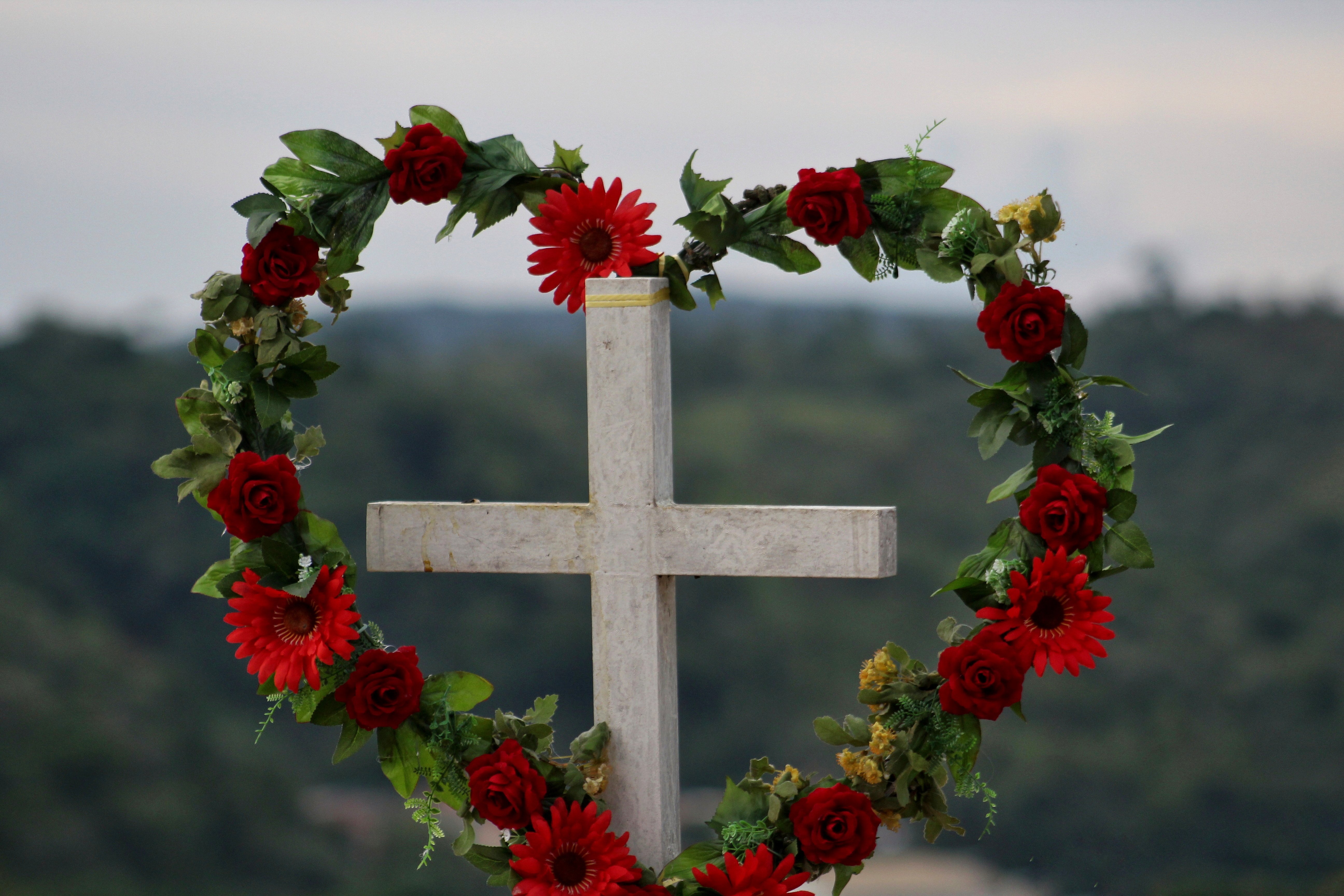 Blumenkranz am Kreuz auf dem Friedhof | Quelle: Shutterstock