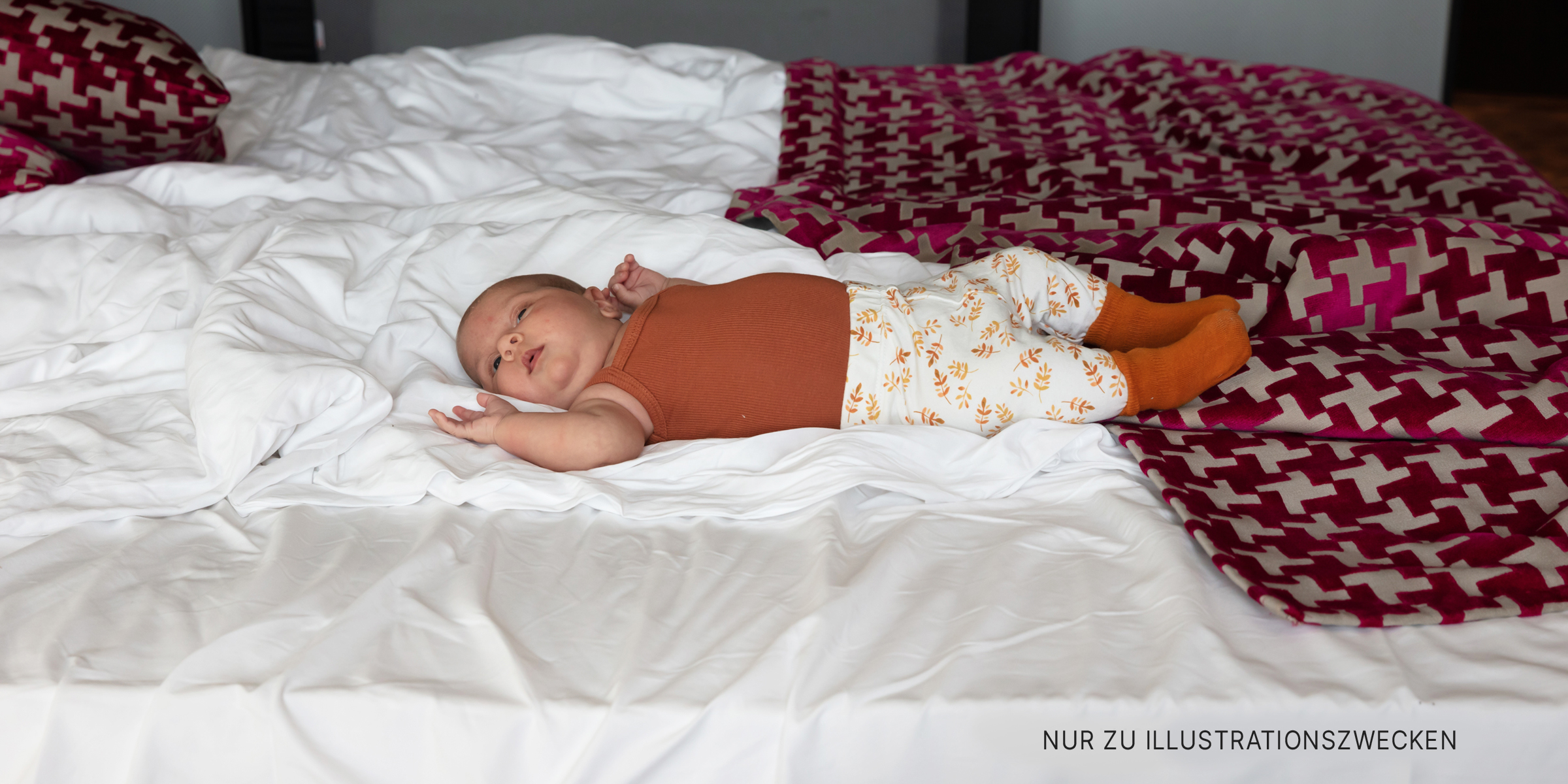 Ein auf dem Bett liegendes Baby | Quelle: Shutterstock