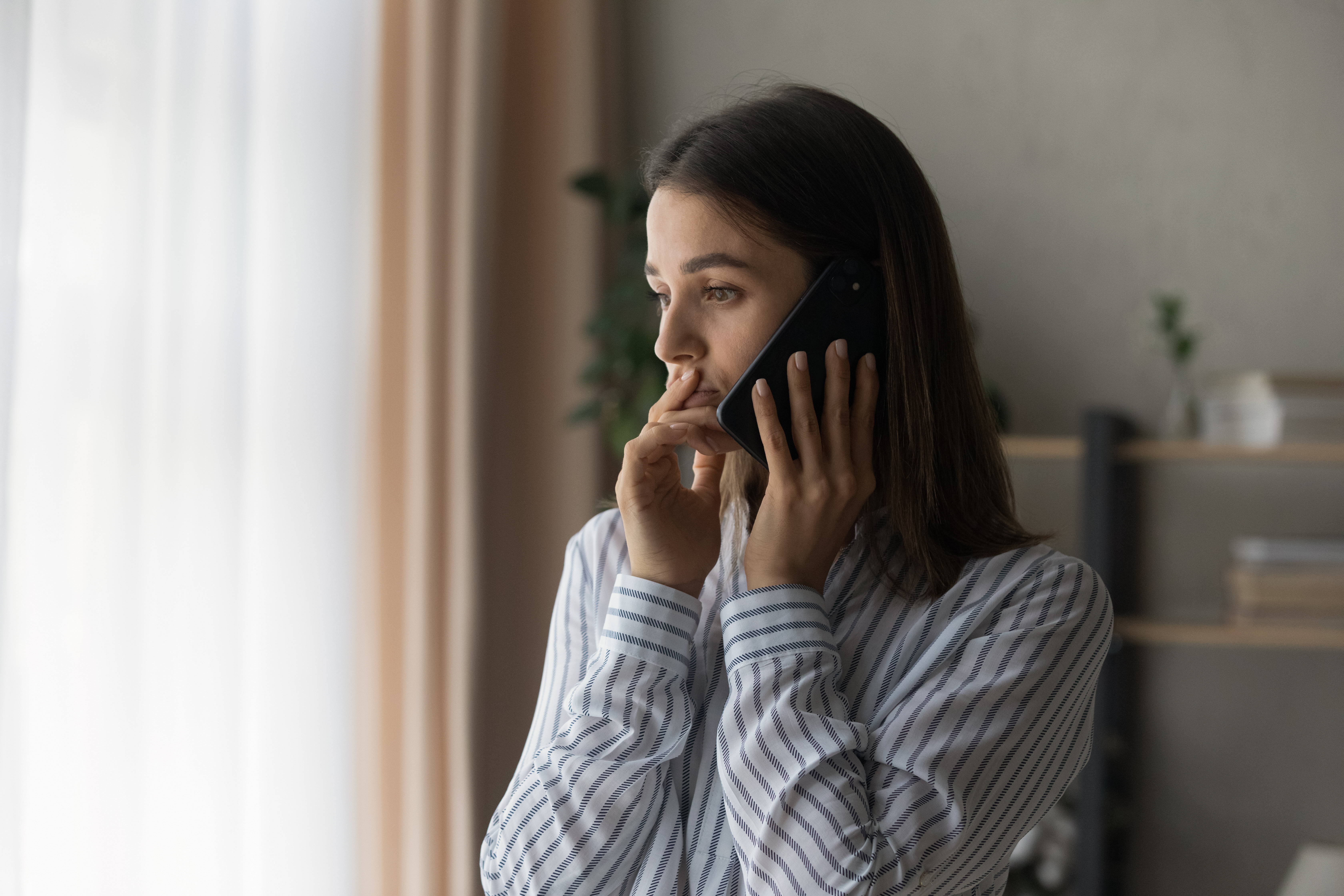 Junges Mädchen am Telefon mit besorgtem Blick | Quelle: Shutterstock