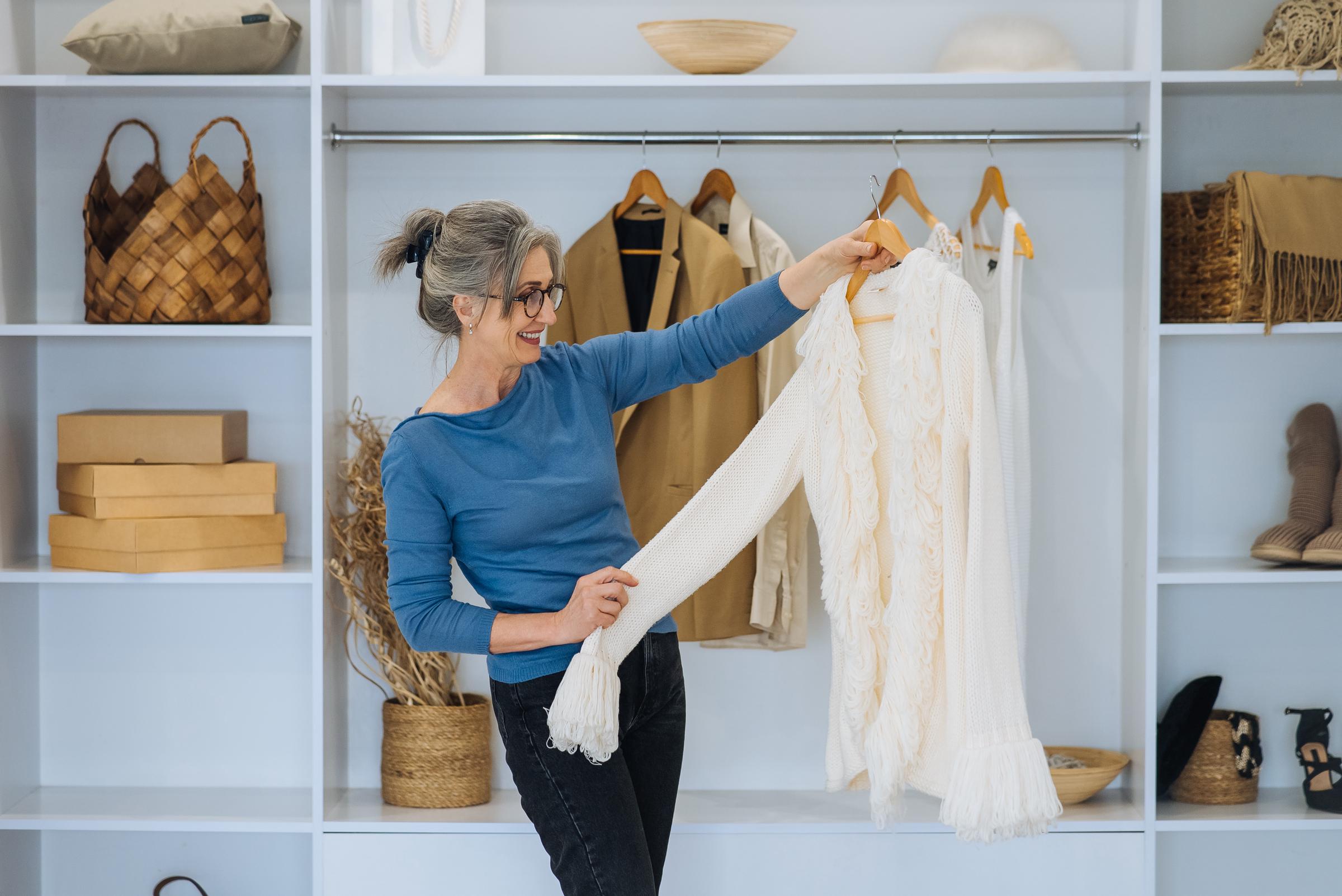 Ältere Frau sucht sich ein Outfit aus ihrem Kleiderschrank aus | Quelle: Freepik