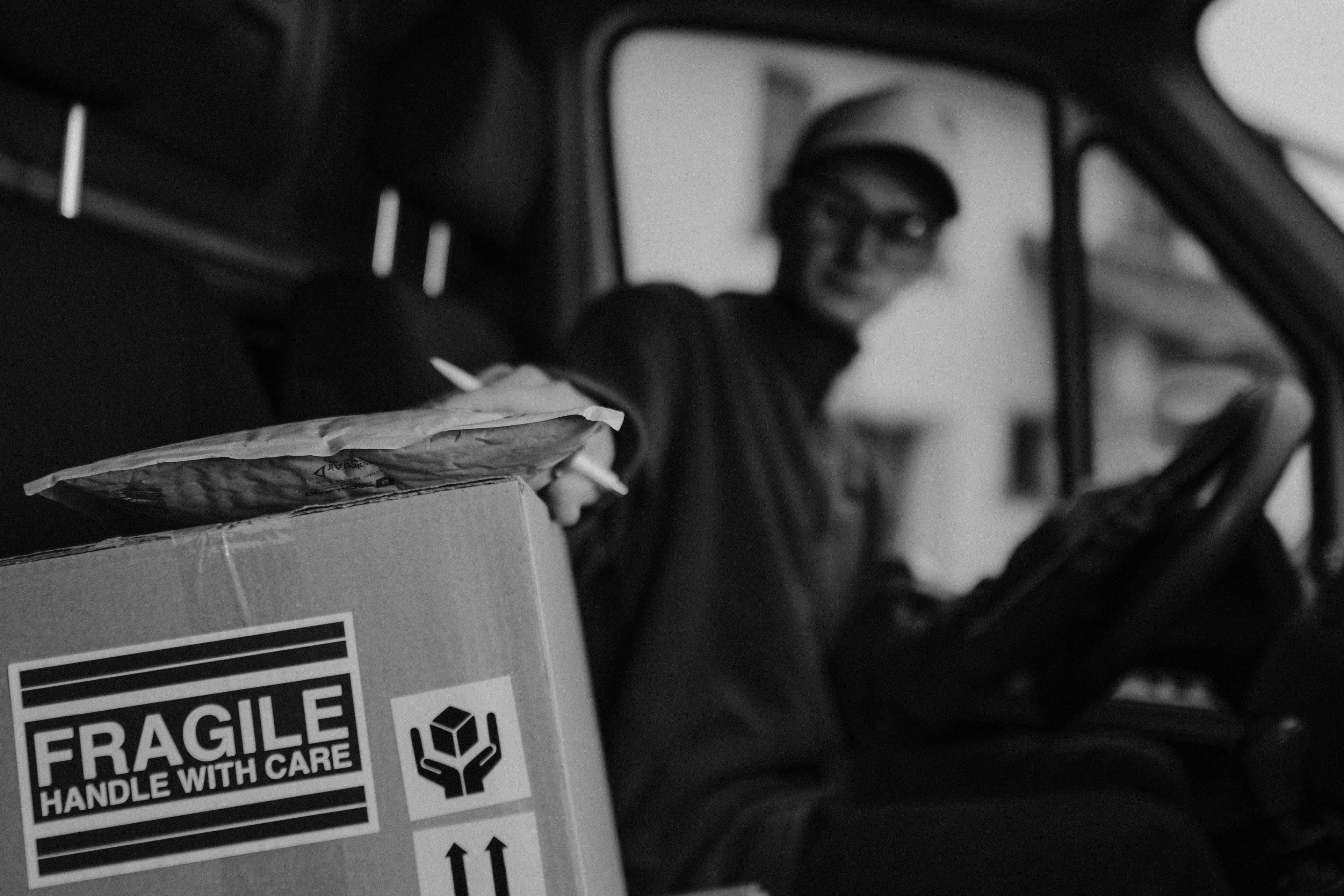 Lieferfahrer beim Umgang mit einem Paket | Quelle: Pexels