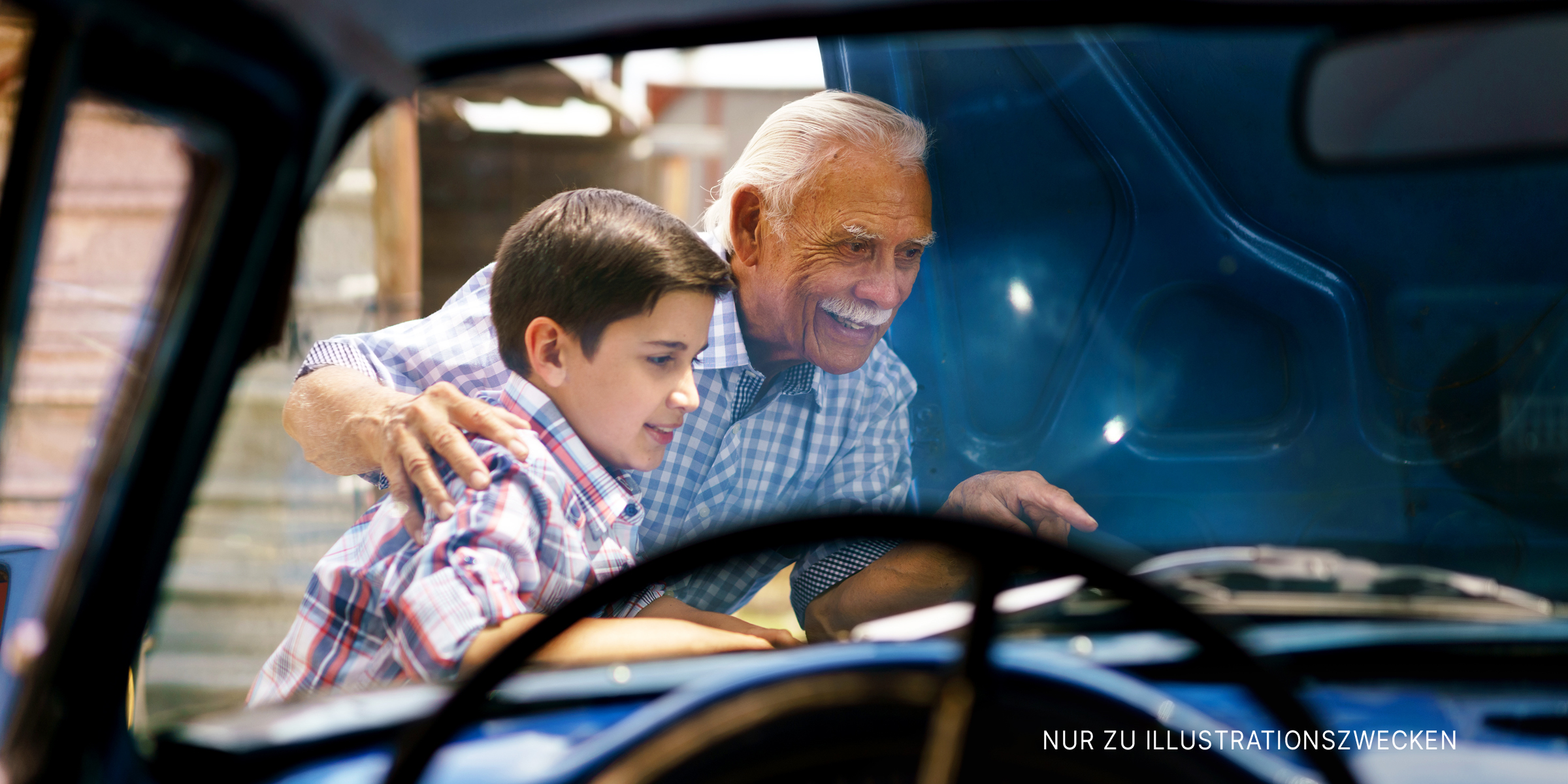 Alter Mann und sein Enkel arbeiten an einem Auto | Quelle: Shutterstock