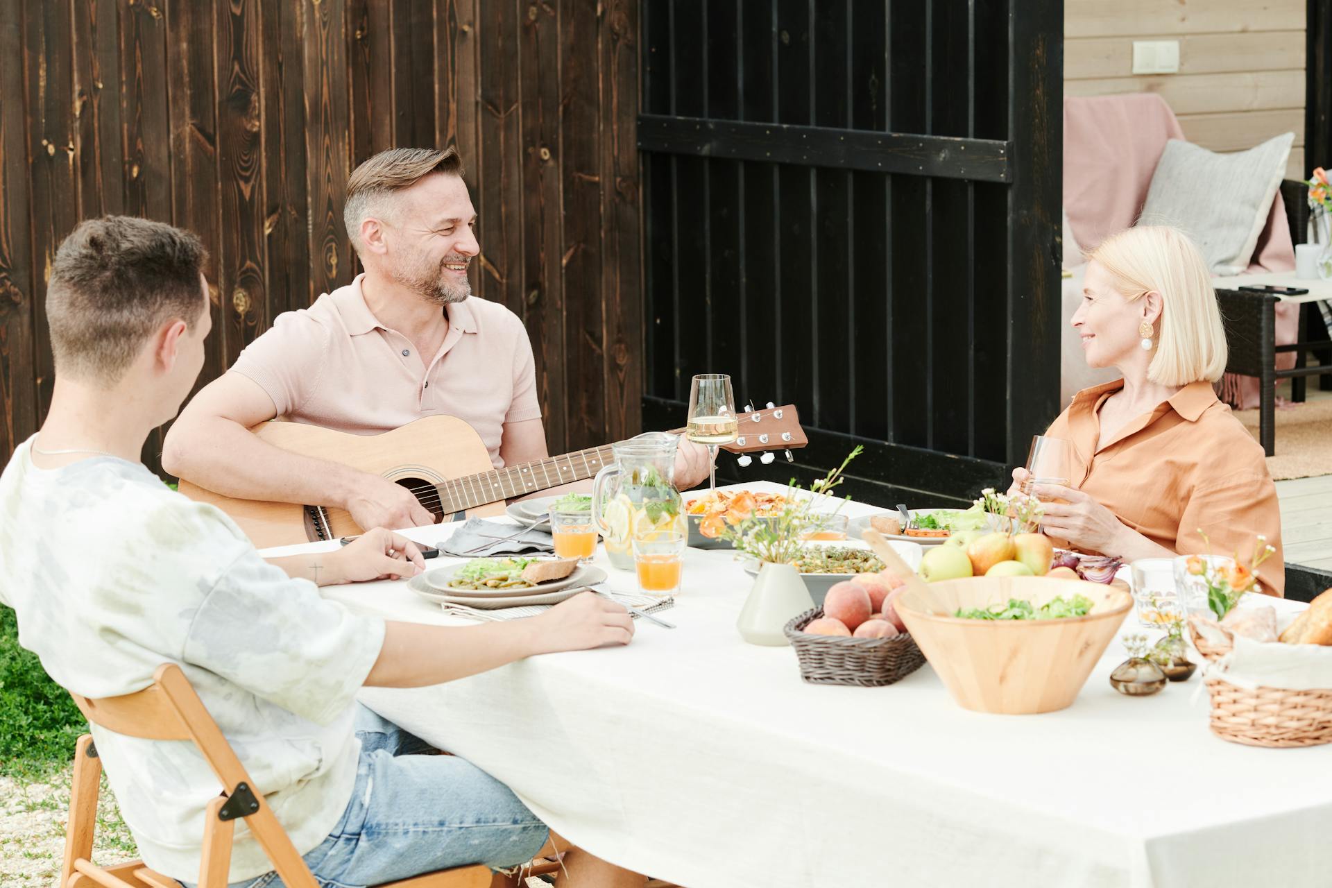 Ein Mann spielt Gitarre während eines Familienessens | Quelle: Pexels