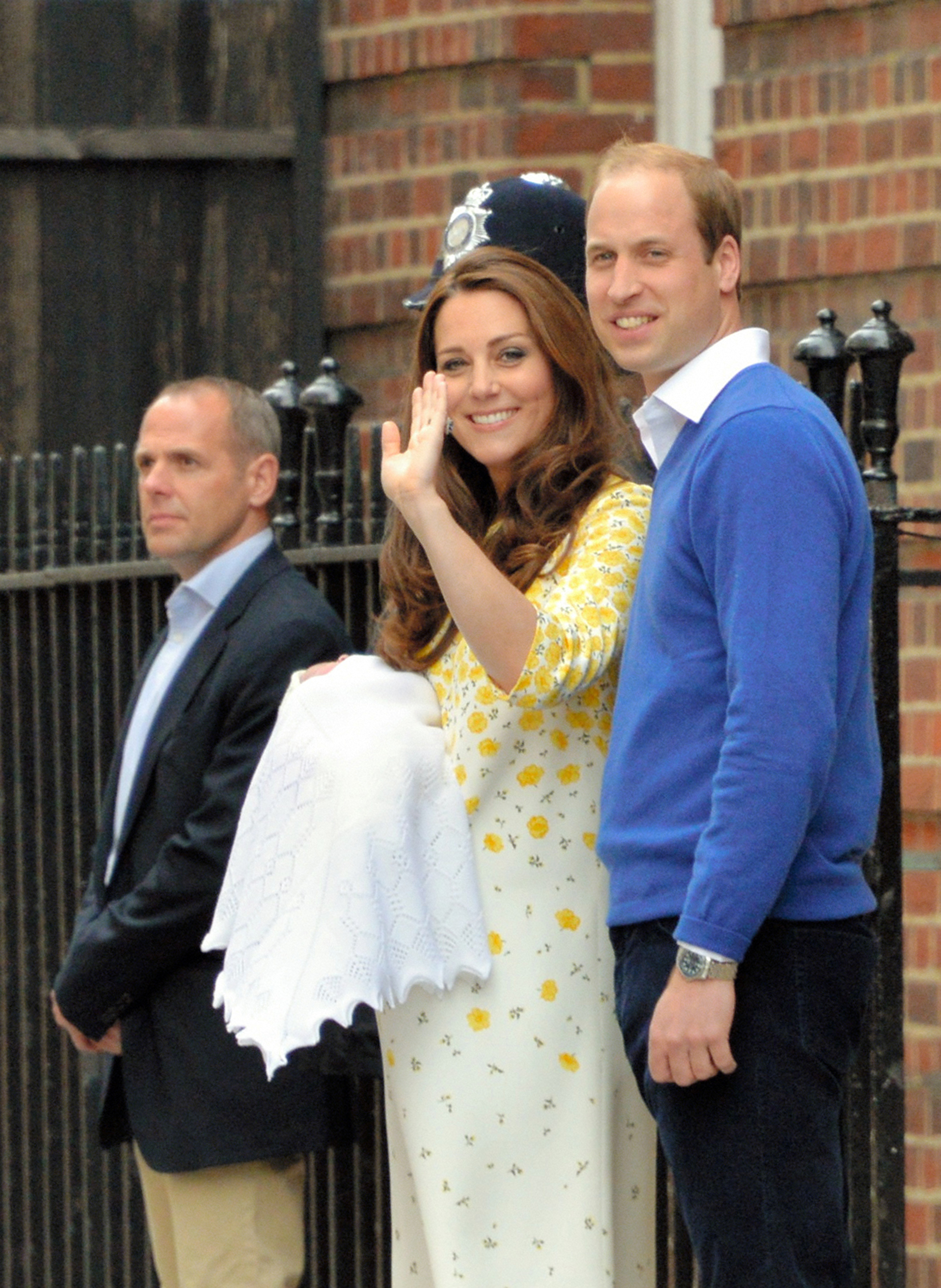 Prinz William, Herzog von Cambridge, lächelt stolz neben Catherine, Herzogin von Cambridge, während sie der jubelnden Menge zuwinkt, die sich vor den Stufen der medizinischen Einrichtung versammelt hat. William trägt einen leuchtend königsblauen Pullover mit V-Ausschnitt über einem weißen Hemd mit offenem Kragen und einer dunkelblauen Hose und steht in der Nähe der Sicherheitskräfte, während das Paar sein frisch angekommenes königliches Familienmitglied der Öffentlichkeit vorstellt. | Quelle: Getty Images