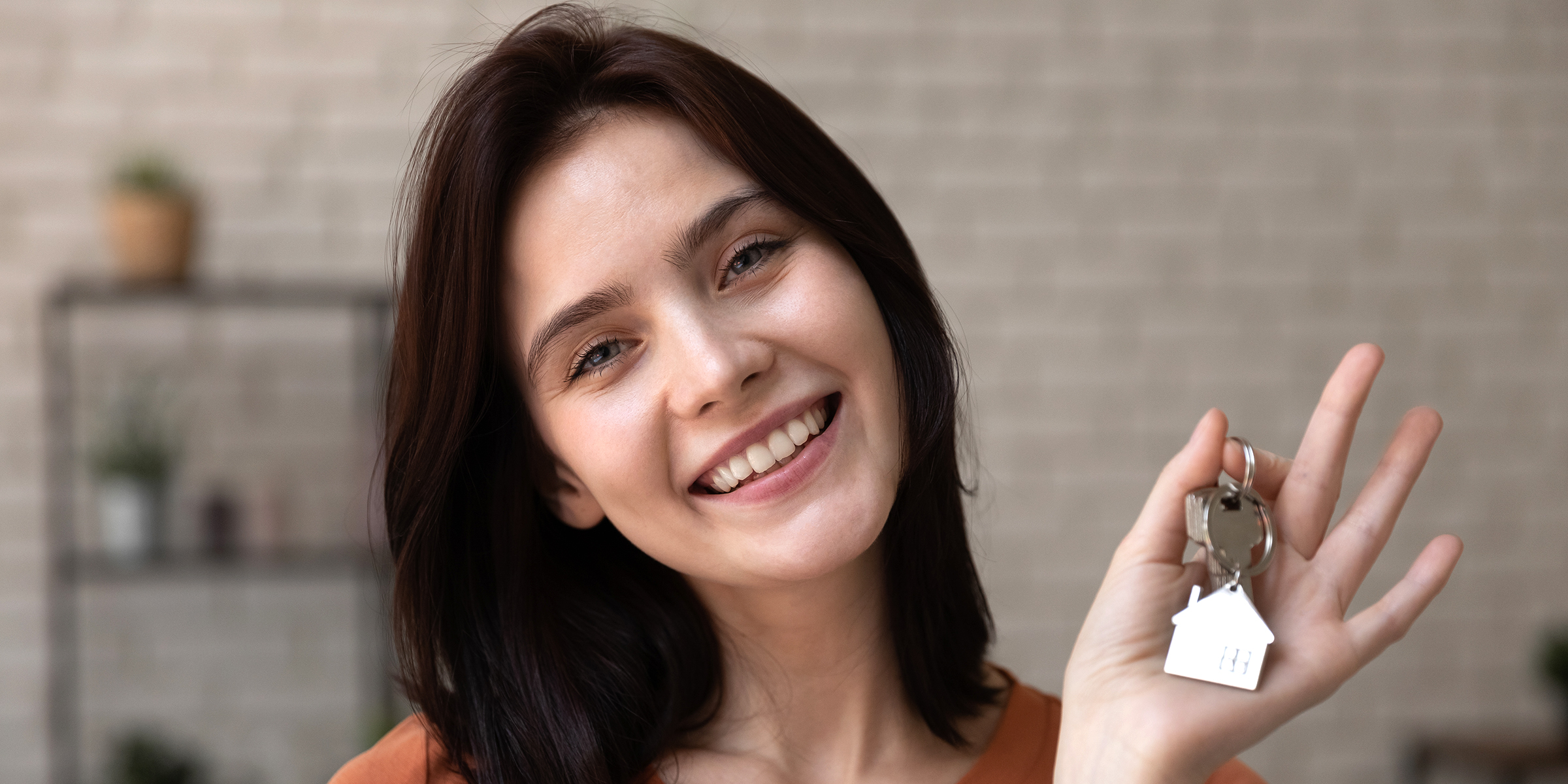 Eine junge Frau hält Hausschlüssel | Quelle: Shutterstock