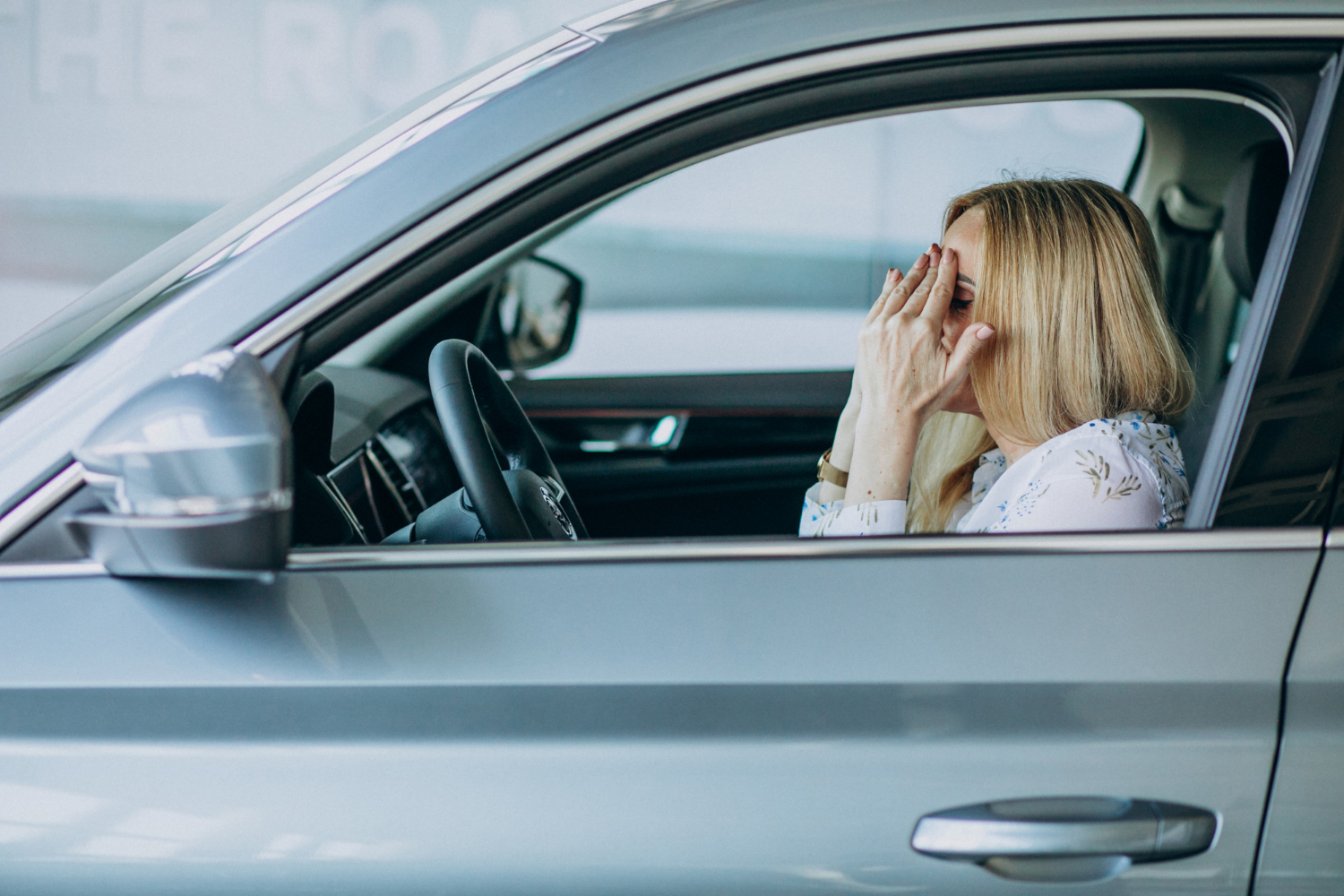 Eine depressive ältere Frau sitzt im Auto | Quelle: Freepik
