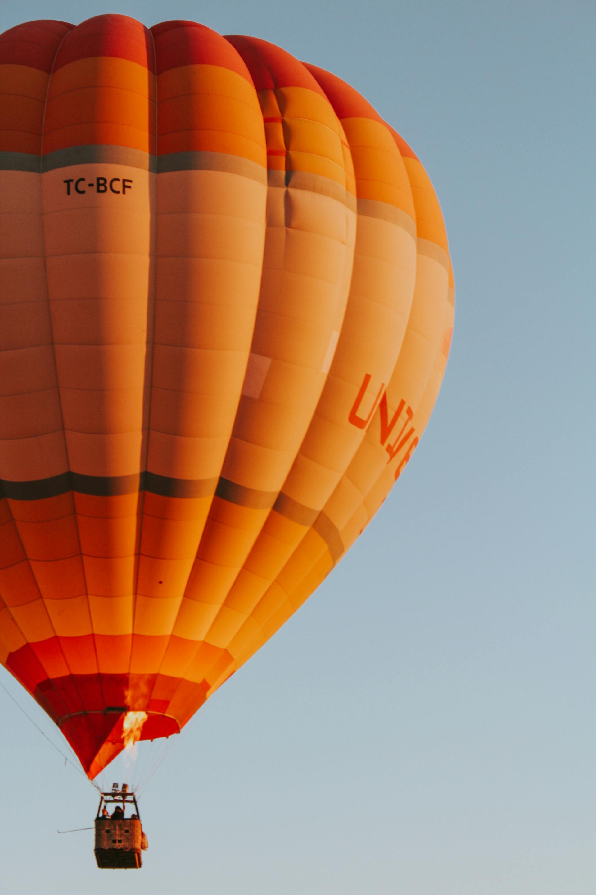 Ein orangefarbener Heißluftballon | Quelle: Pexels