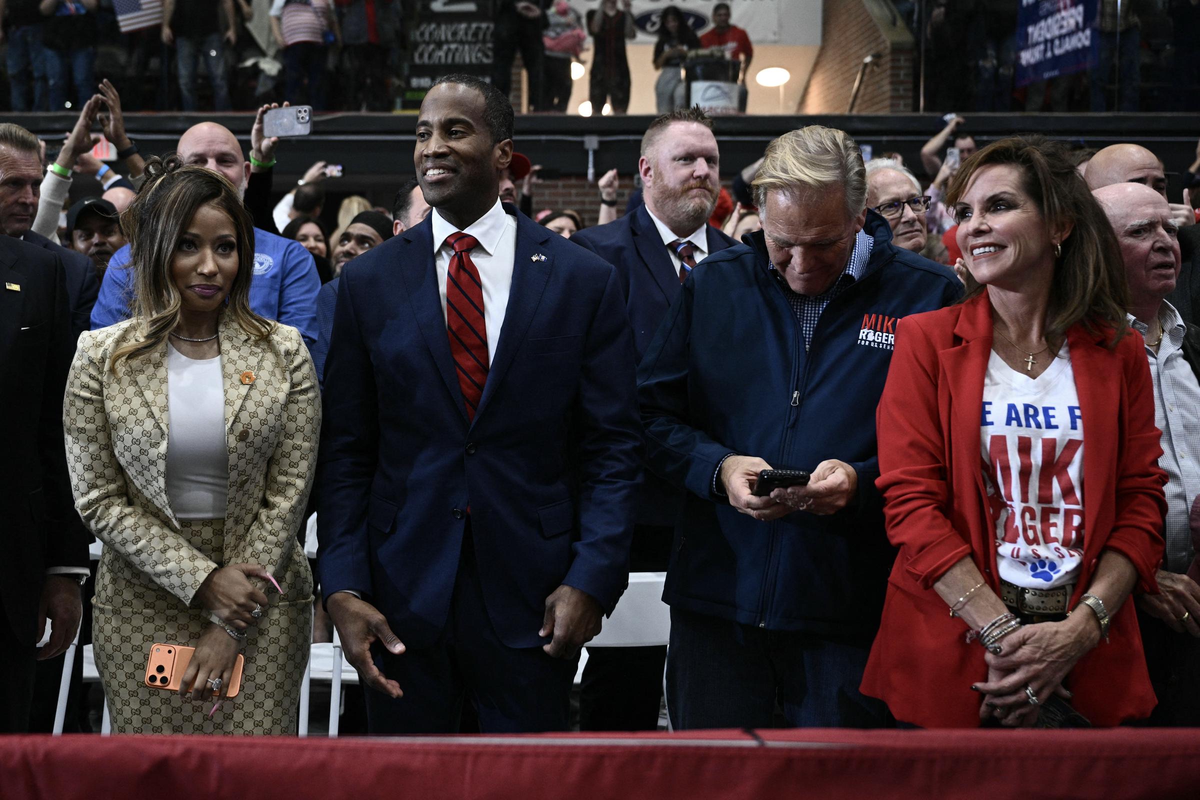 Nicki Minaj steht zusammen mit anderen Gästen bei der Kundgebung neben Anhängern des Senatskandidaten aus Michigan, Mike Rogers. Die Veranstaltung brachte Politiker und Wahlkampfunterstützer zusammen, während die Zuschauer ihre Handys hochhielten, um den Moment festzuhalten. | Quelle: Getty Images