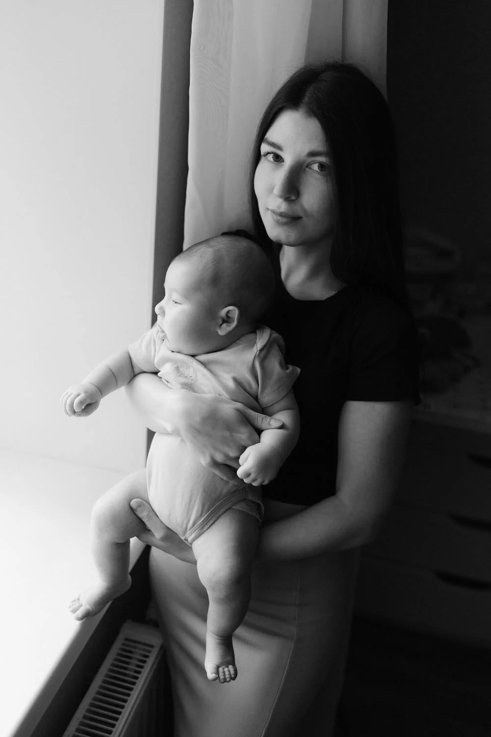 Ein Schwarz-Weiß-Foto von einer Frau, die ein Baby hält | Quelle: Pexels