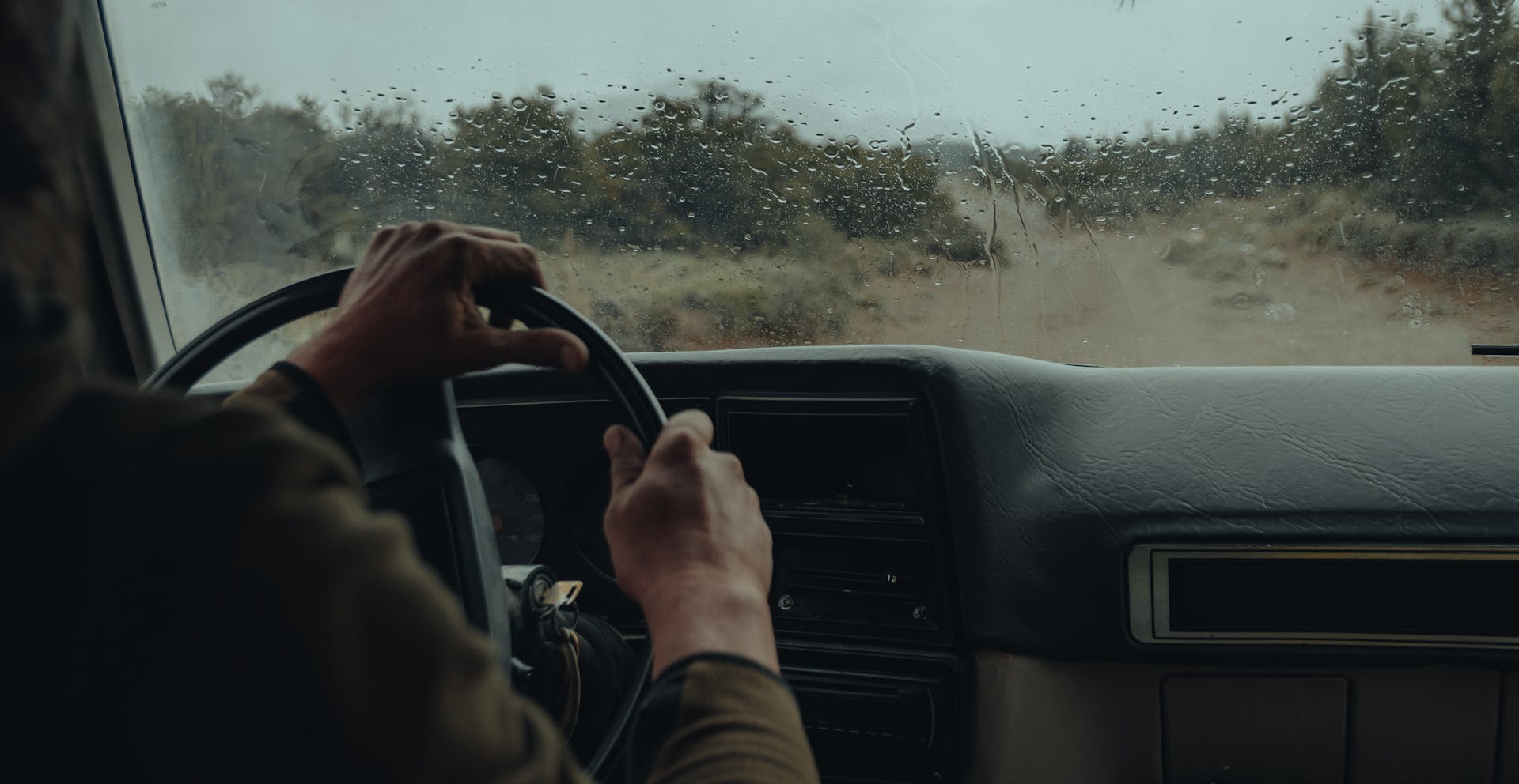 Ein Mann am Steuer eines Autos an einem regnerischen Tag | Quelle: Pexels