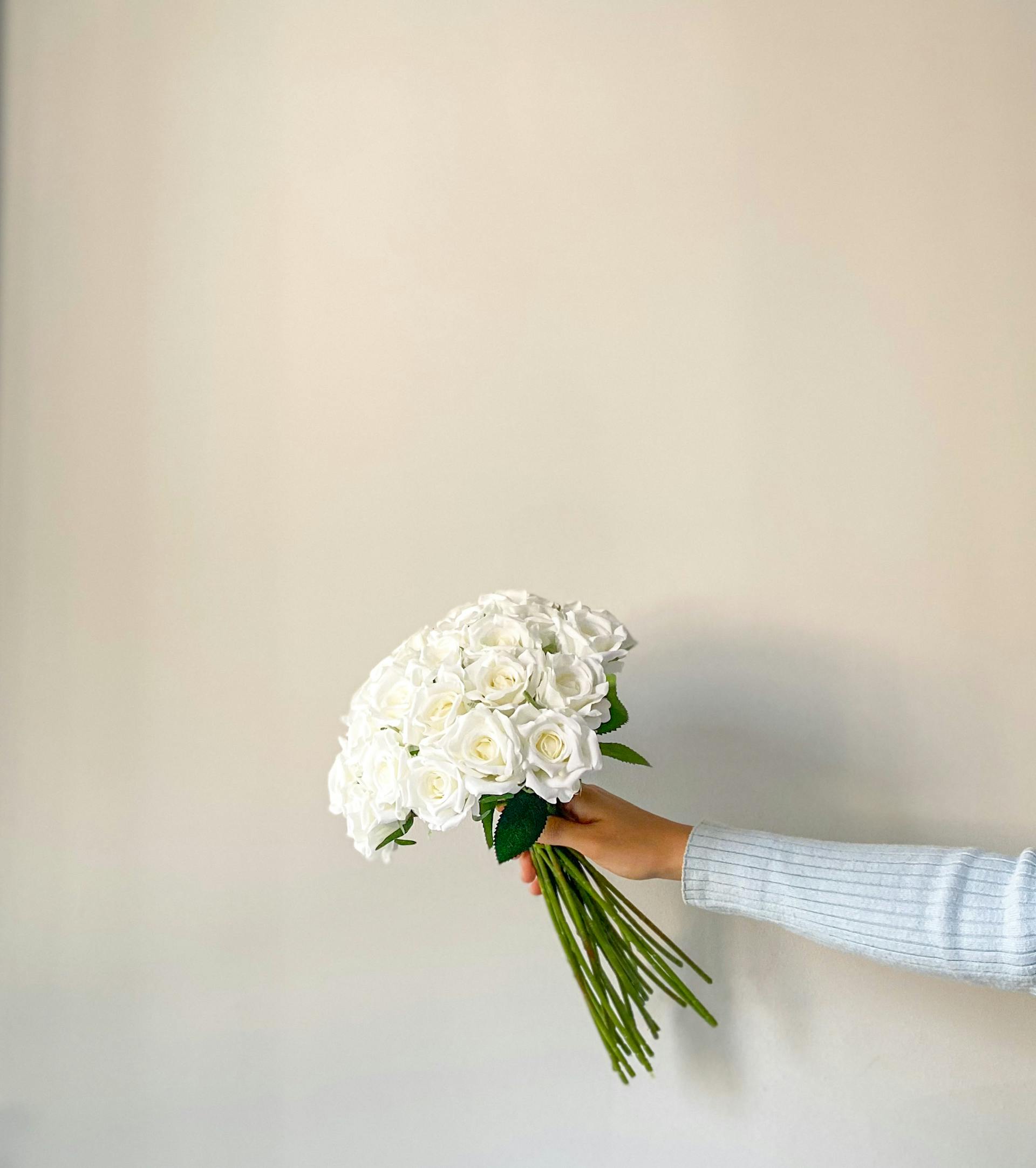 Eine Frau hält einen Strauß weißer Rosen | Quelle: Pexels