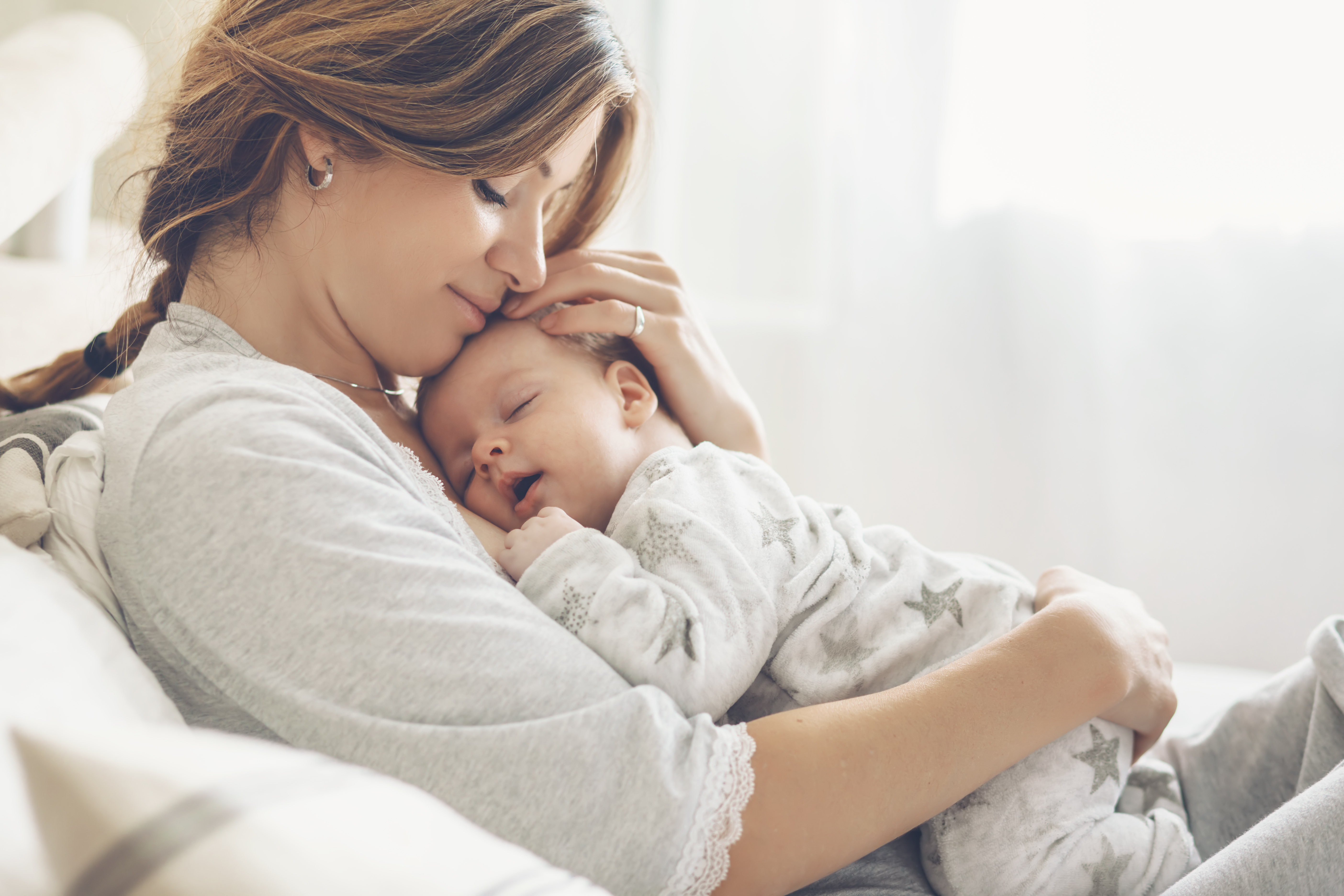 Eine Mutter, die ihr neugeborenes Kind kuschelt | Quelle: Shutterstock