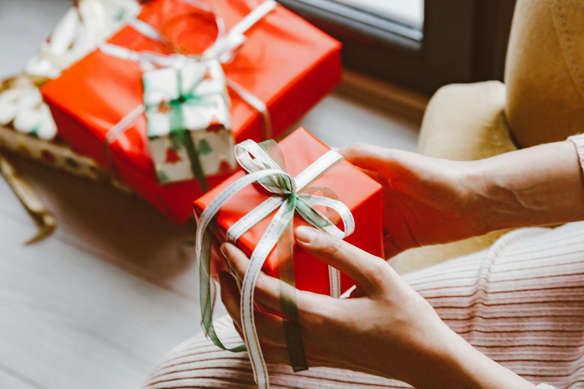 Uma mulher abre um presente de Natal | Fonte: Pexels