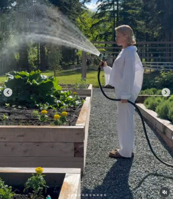 In einem lässigen weißen Langarm-Set bewässert Pamela Anderson unter der warmen Sommersonne in Arcady üppige Hochbeete mit einem Schlauch. Umgeben von gelben Ringelblumen, saftigem Blattgrün und Kieswegen genießt sie die sinnliche Schönheit, ihr Grundstück wieder zum Leben zu erwecken, und kommentiert den Moment mit den Worten: „Ich betrachte das Leben als einen Garten … Man kann neu pflanzen, von vorne anfangen und ihn zu seinem eigenen machen. 🤍 Liebe, P“. | Quelle: Instagram/pamelaanderson