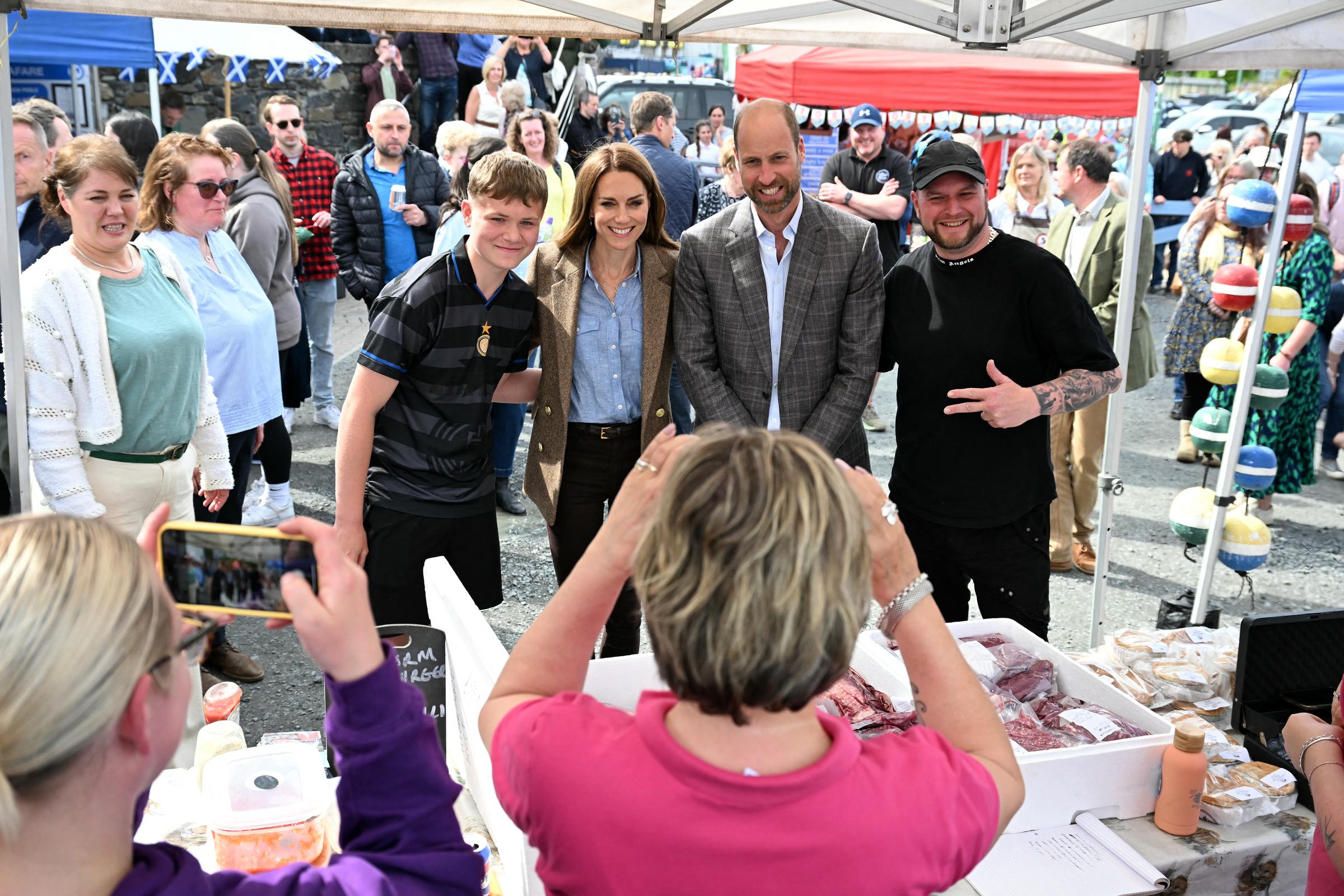 William und Catherine posieren für ein fröhliches Foto mit Einheimischen an einem Marktstand in Tobermory. Das Paar besuchte den Markt, um das Unternehmertum in der Gemeinde und kleine Geschäftsinitiativen auf der Insel zu fördern.