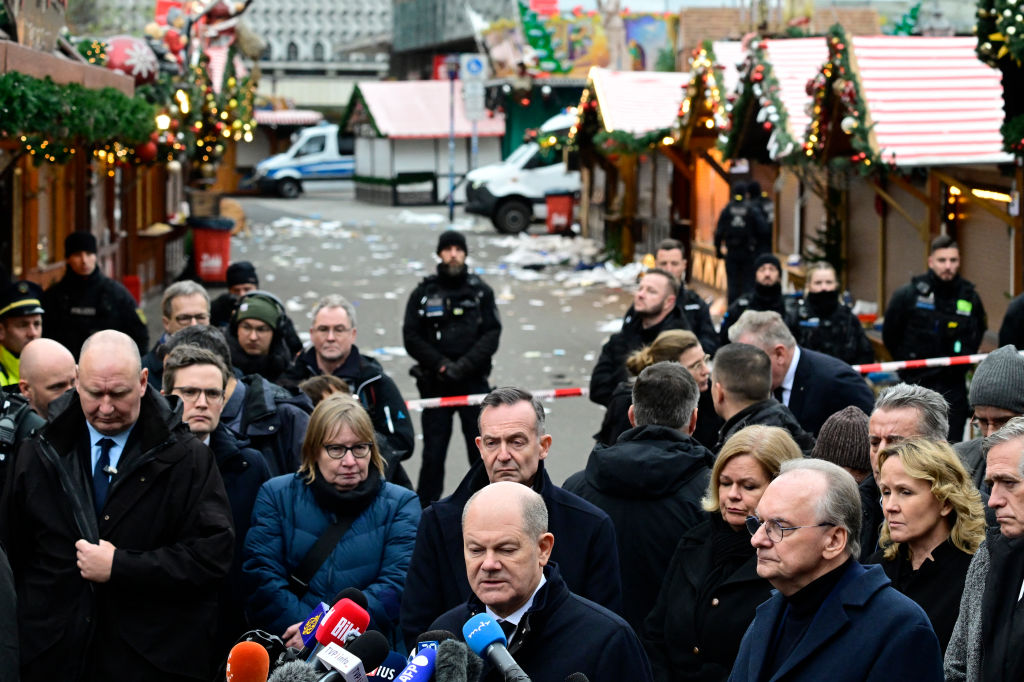 Der deutsche Bundeskanzler Olaf Scholz (Mitte) spricht vor der Presse, während der Ministerpräsident von Sachsen-Anhalt, Reiner Haseloff (Mitte rechts), bei einem Besuch am Ort eines Auto-Rammangriffs auf einen Weihnachtsmarkt in Magdeburg, Ostdeutschland, am 21. Dezember 2024 zusieht | Quelle: Getty Images