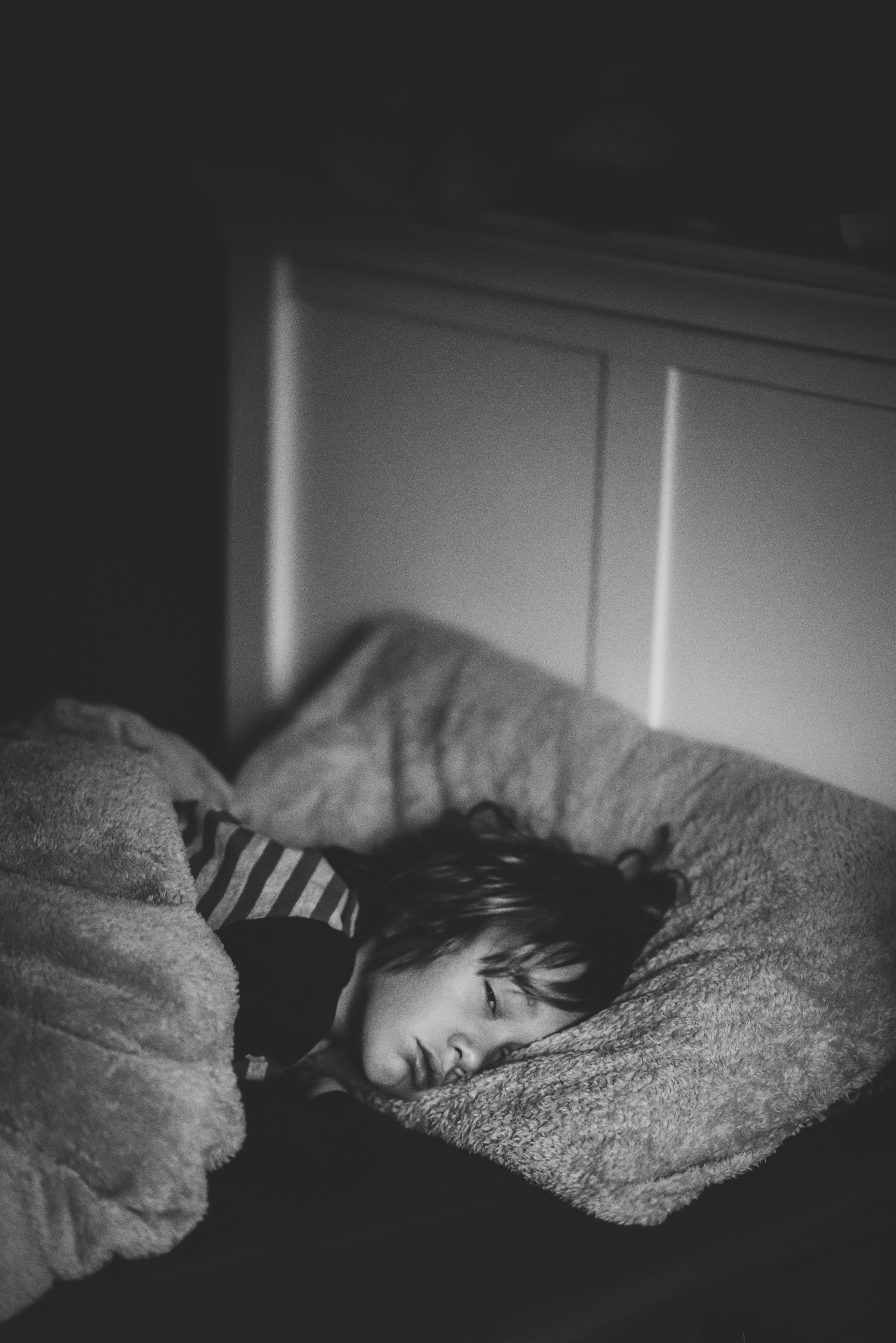 Ein kleiner Junge liegt im Bett | Quelle: Unsplash