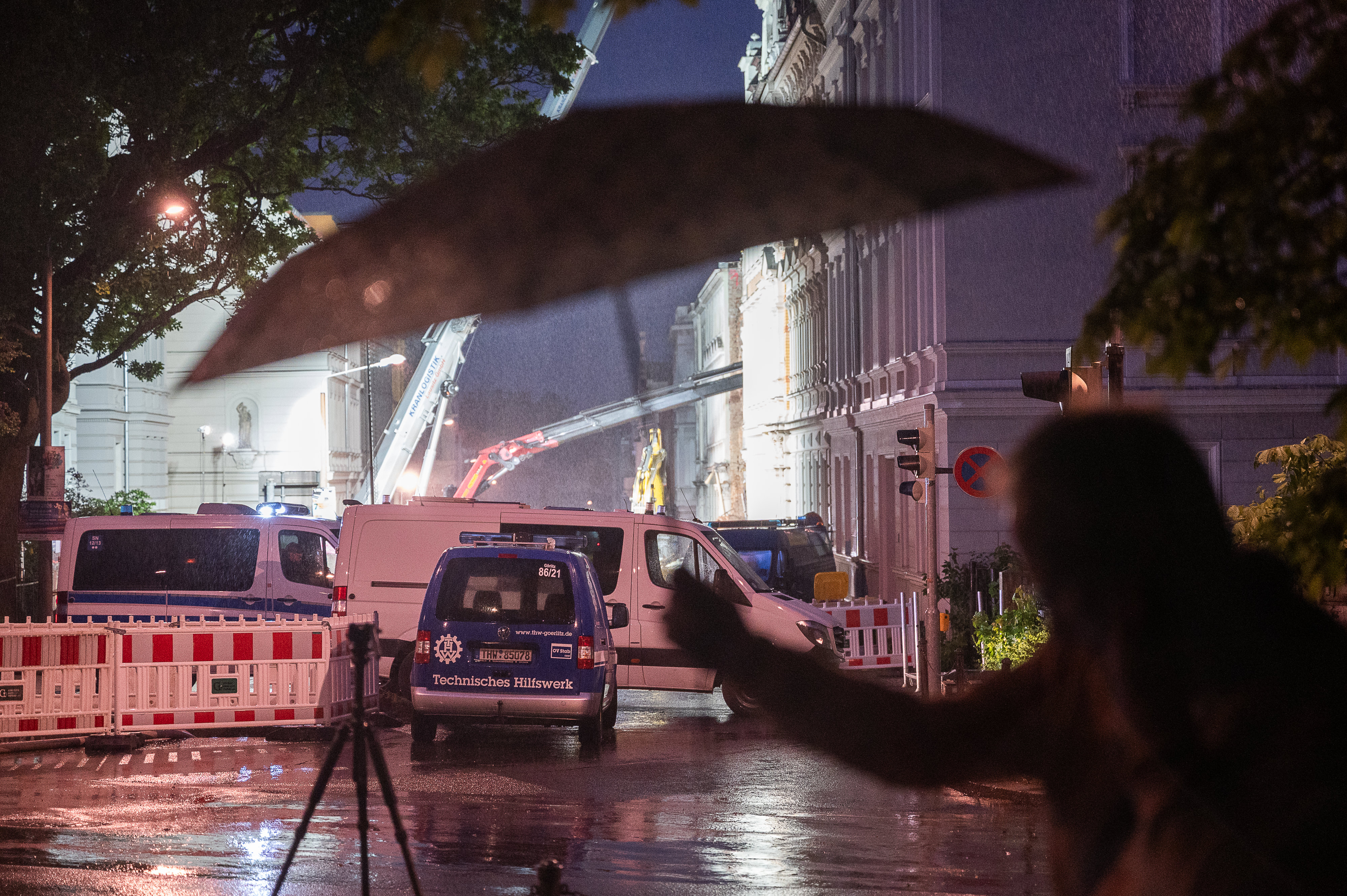 Ein Mann hält einen Regenschirm vor dem Geschehen | Quelle: Getty Images