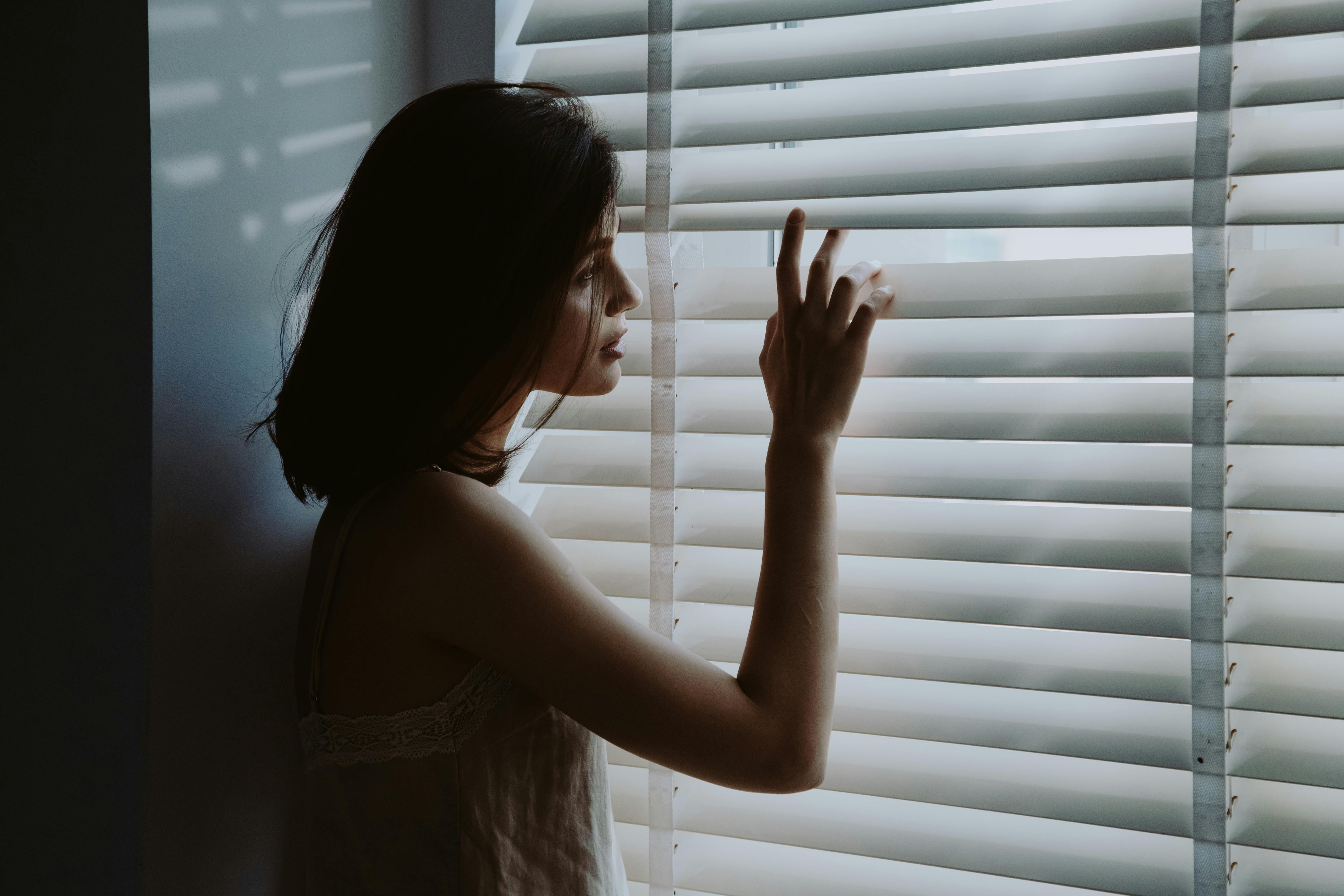 Eine Frau, die durch das Fenster schaut | Quelle: Pexels