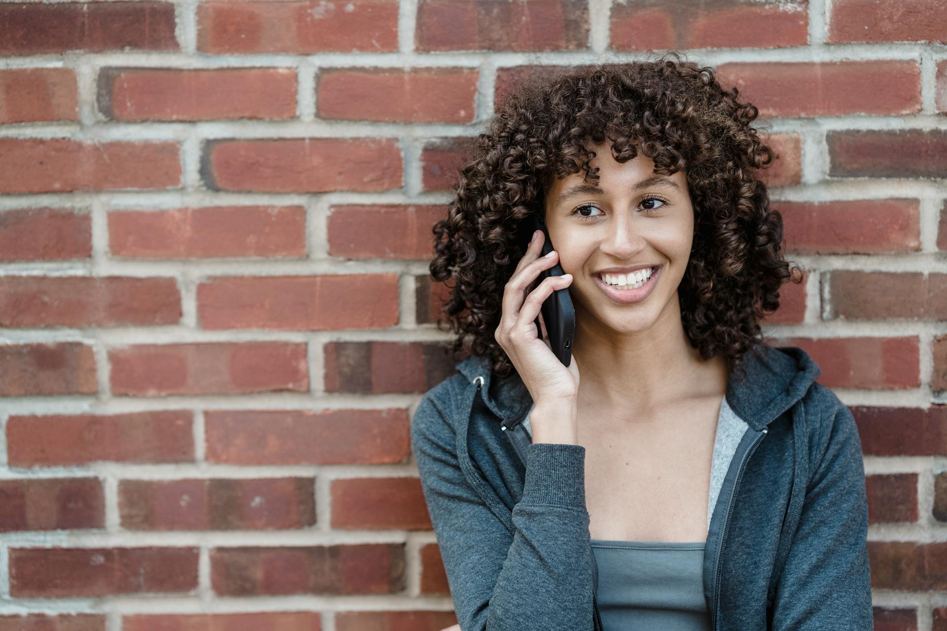 Eine Frau lächelt während eines Telefonats | Quelle: Pexels