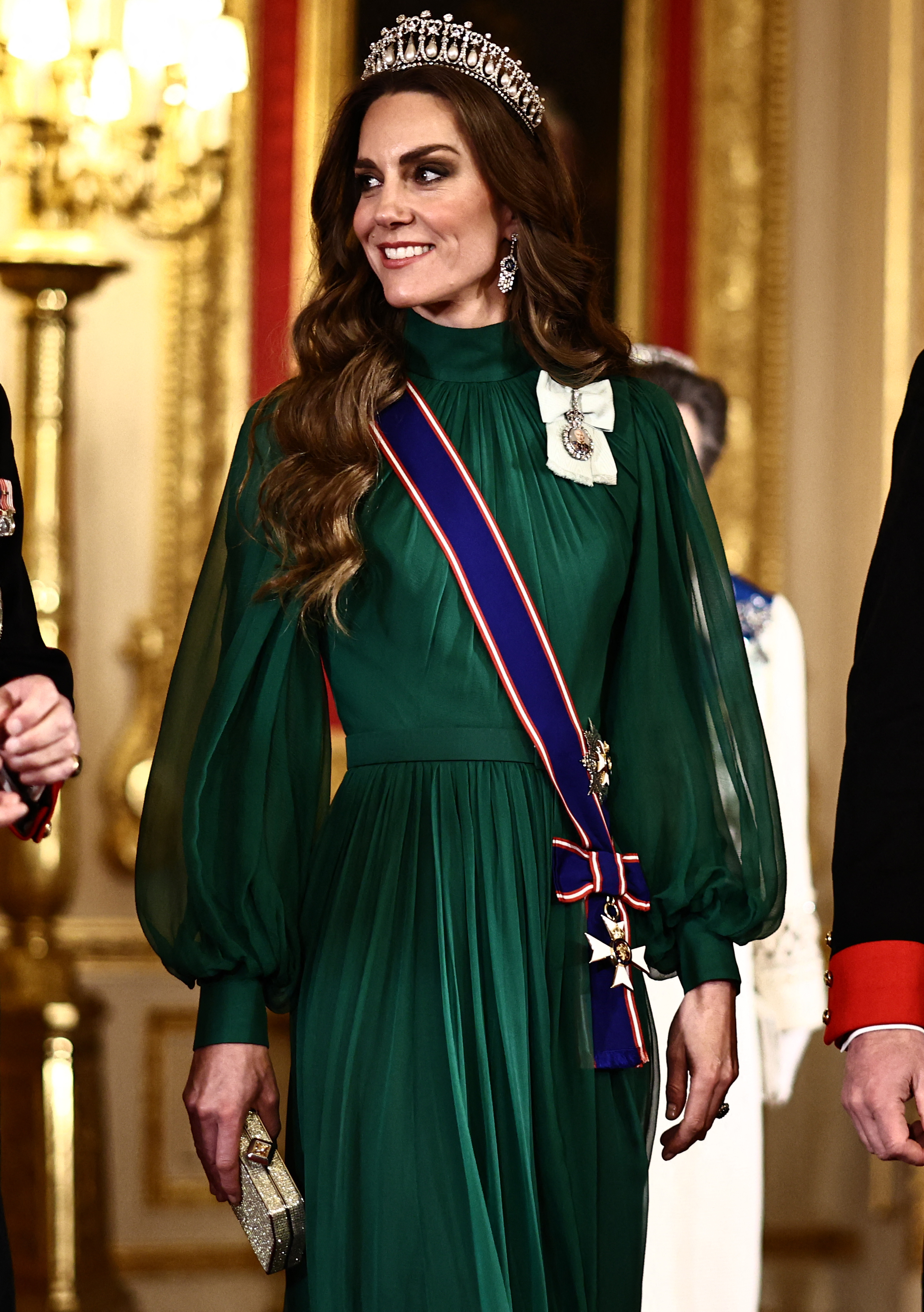 Catherine, Prinzessin von Wales, trifft am 18. März 2026 zum Staatsbankett in der St. George’s Hall im Windsor Castle ein, das zu Ehren des nigerianischen Präsidenten stattfindet. Sie strahlt abendlichen Glamour aus, trägt Catherine ein fließendes smaragdgrünes Chiffonkleid von Emilia Wickstead mit gerafftem hohem Ausschnitt und wallenden, transparenten Bischofsärmeln, ergänzt durch Königin Marys „Lover’s Knot“-Tiara, Diamant-Ohrringe, eine funkelnde goldene Clutch, die Schärpe des Royal Victorian Order und den Royal Family Order von König Charles III. | Quelle: Getty Images