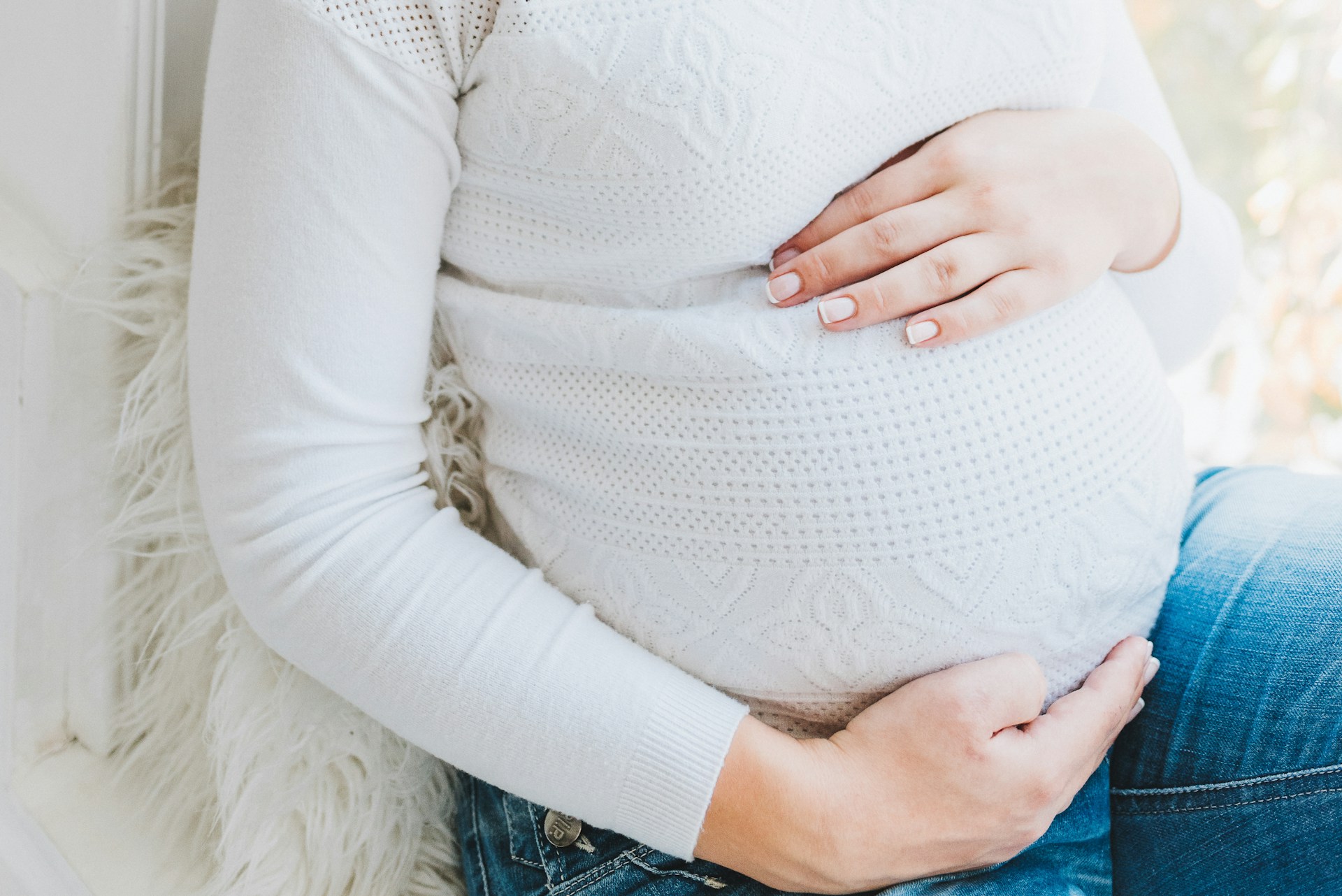 Eine schwangere Frau, die ihren Babybauch hält | Quelle: Unsplash