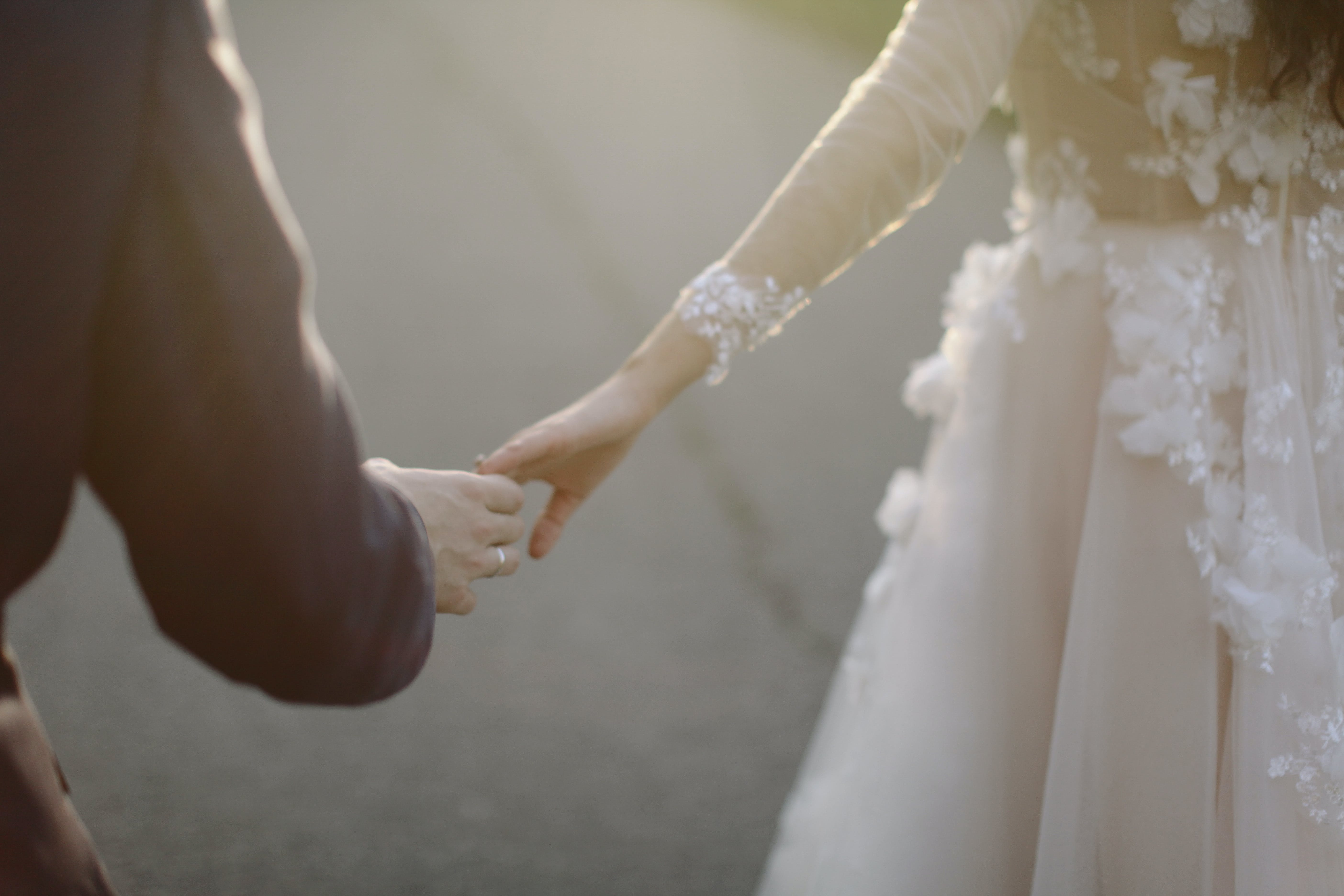 Eine Braut und ein Bräutigam, die sich an den Händen berühren | Quelle: Pexels