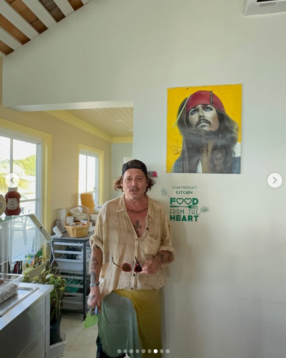 Johnny Depp posiert neben seinem Captain Jack Sparrow-Kunstwerk in Lorraine's Cafe & High Tide in Exuma, Bahamas, am 30. August 3034 | Quelle: Instagram/killerbartender