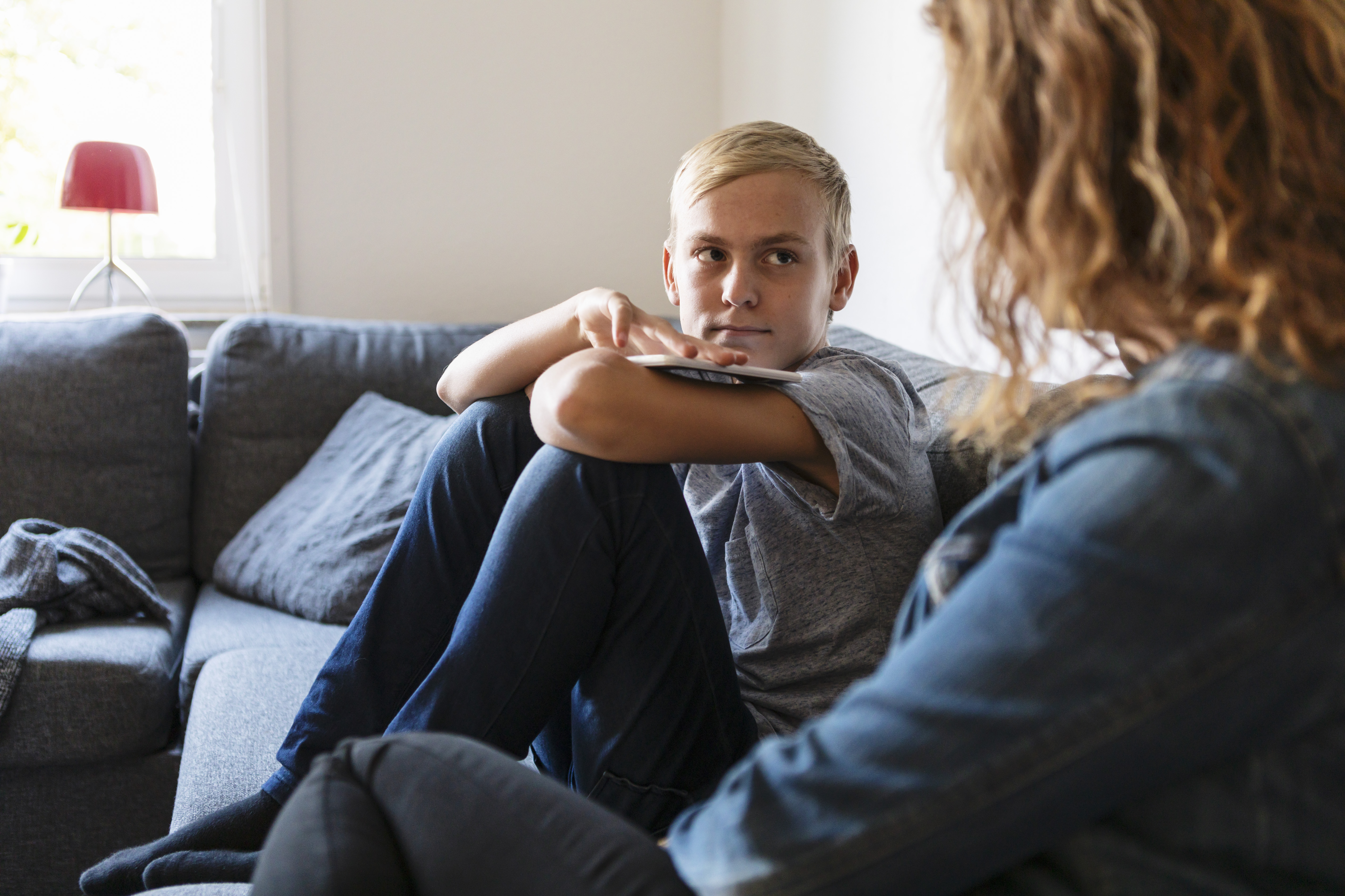 Teenager-Junge im Gespräch mit seiner Mutter | Quelle: Getty Images