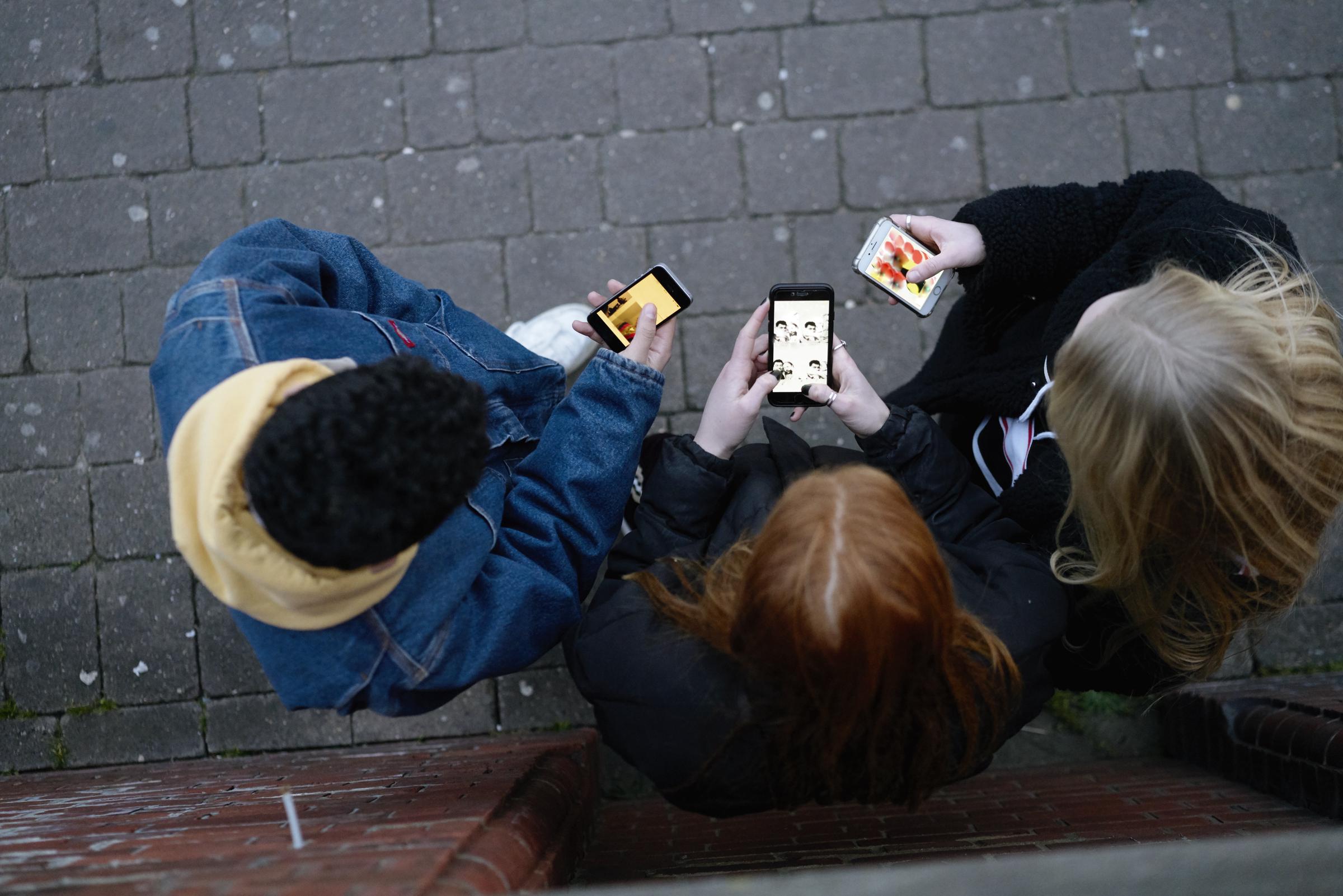 Eine Gruppe von Freunden an ihren Telefonen | Quelle: Getty Images