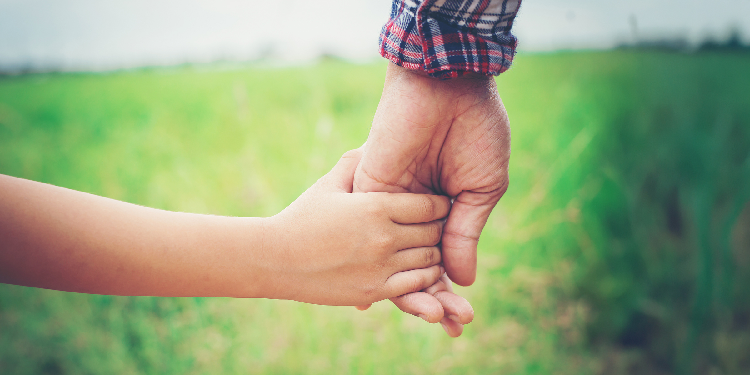 Ein Kind hält die Hand eines Mannes | Quelle: Shutterstock