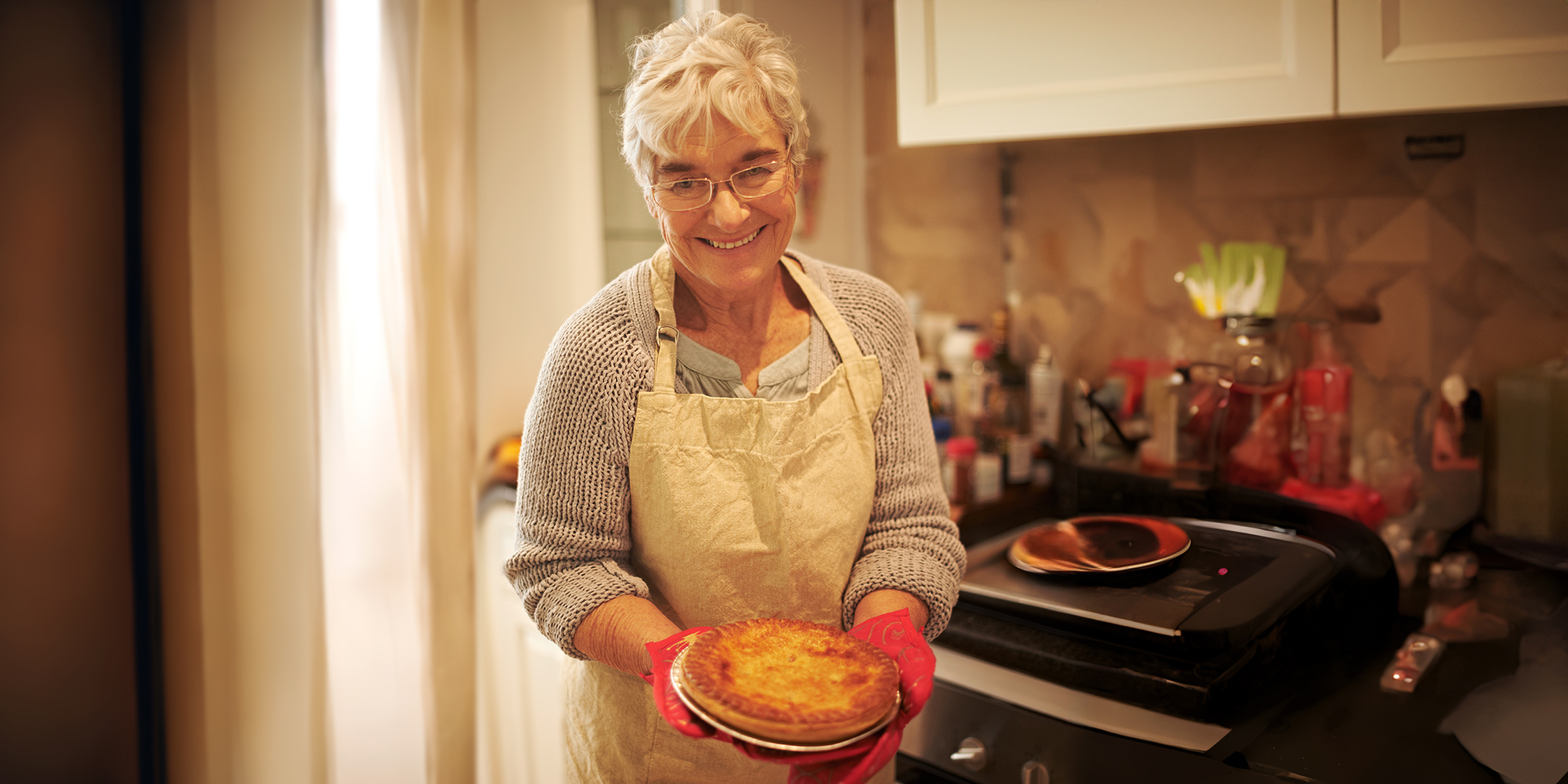 Eine glückliche Frau, die einen Kuchen hält | Quelle: Shutterstock