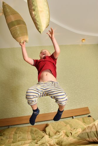 Junge springt auf Bett | Quelle: Shutterstock