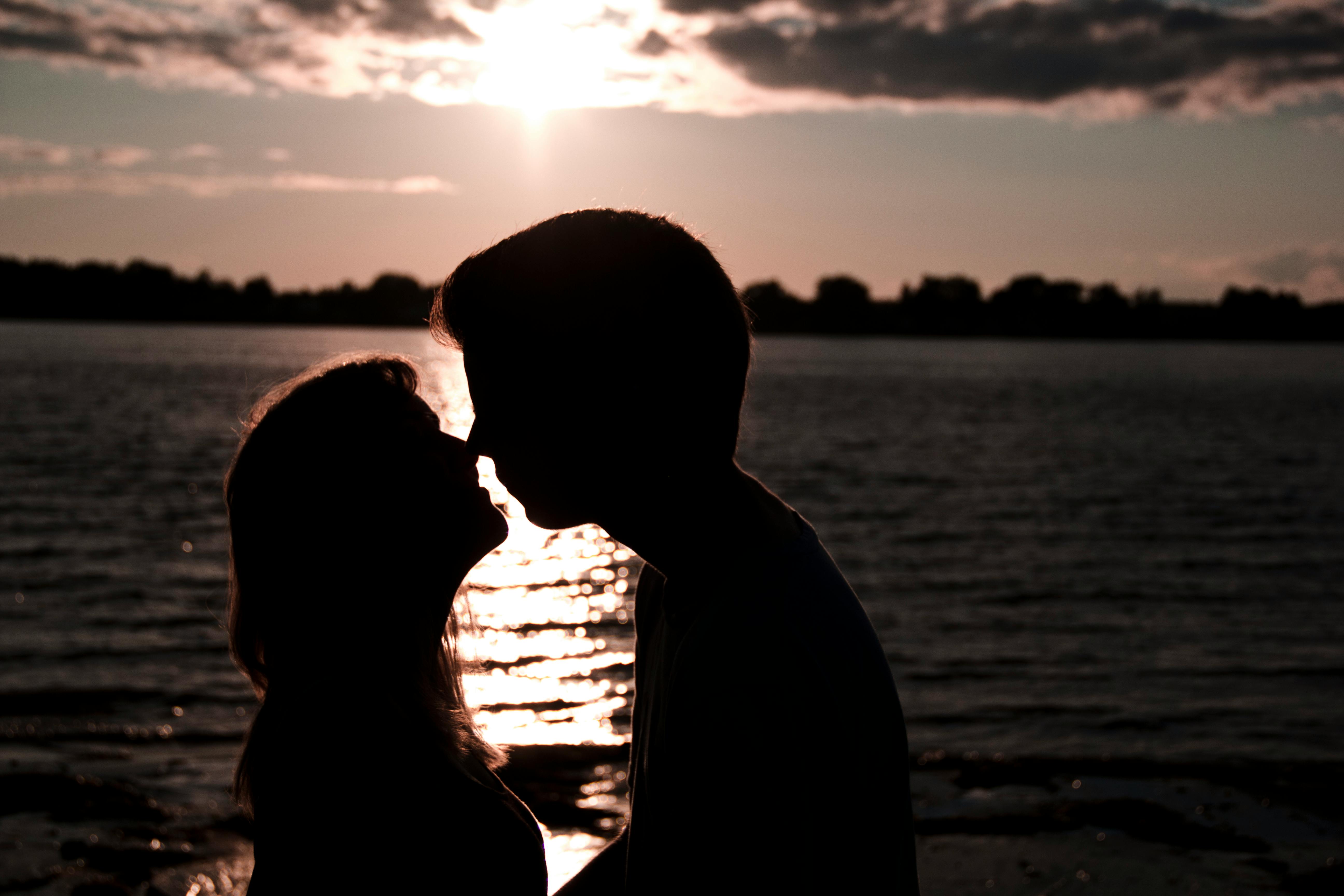 Ein Silhouettenfoto von einem Mann und einer Frau, die sich küssen | Quelle: Pexels