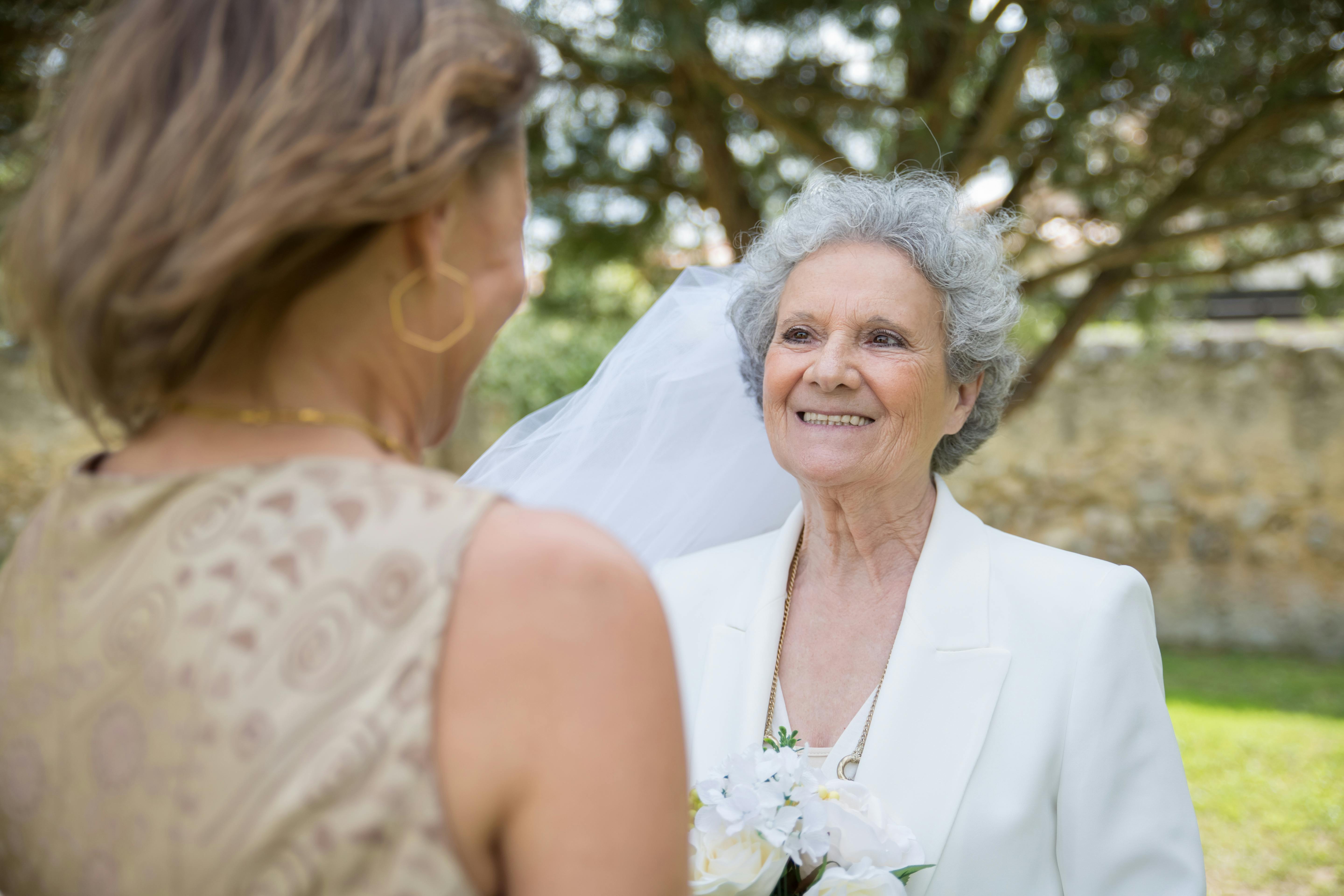 Eine Frau in einem Hochzeitskleid im Gespräch mit einer Brautjungfer | Quelle: Pexels