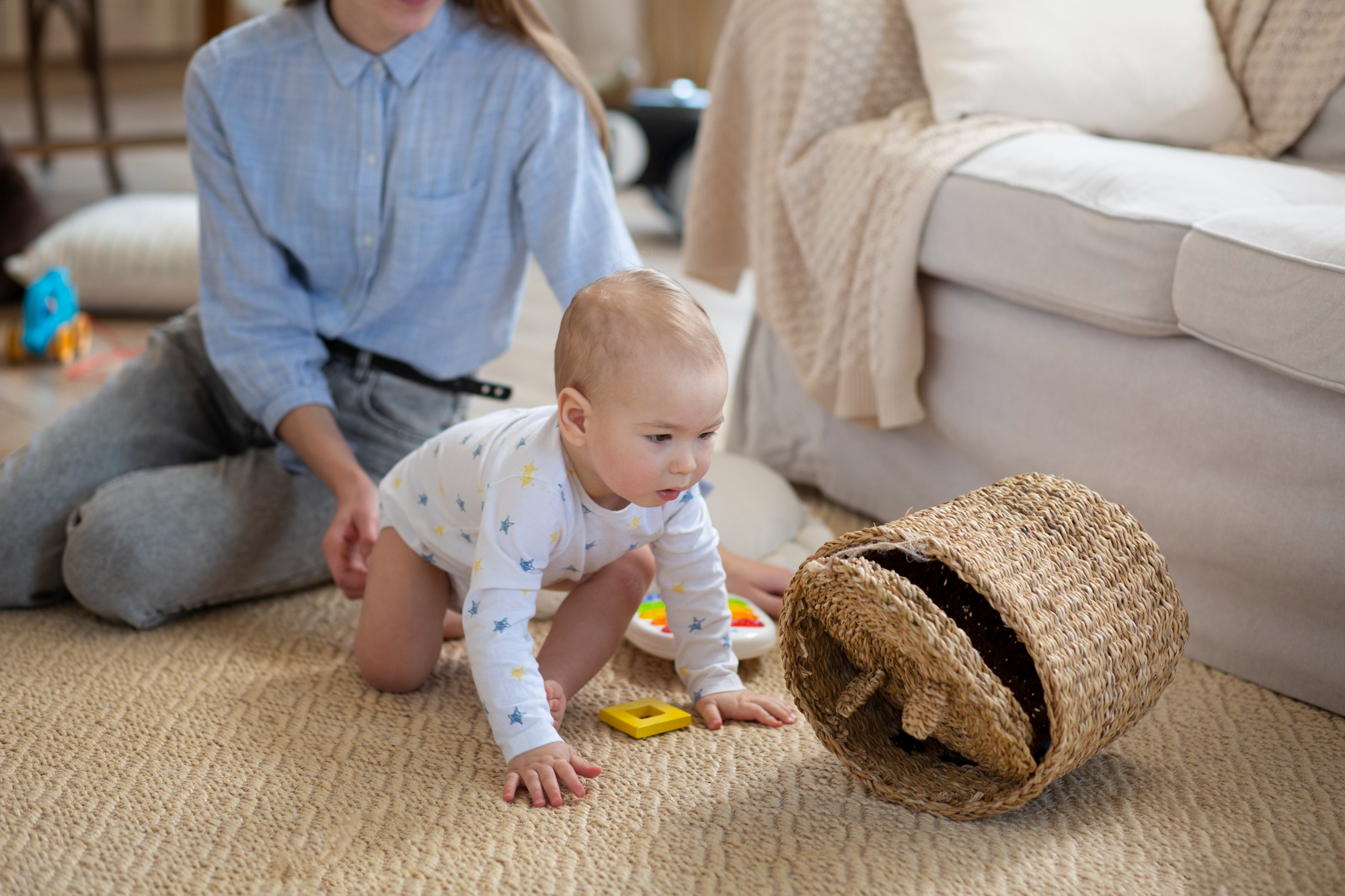 Eine Nahaufnahme eines Kindermädchens, das ein krabbelndes Baby in einem Zimmer hält | Quelle: Freepik