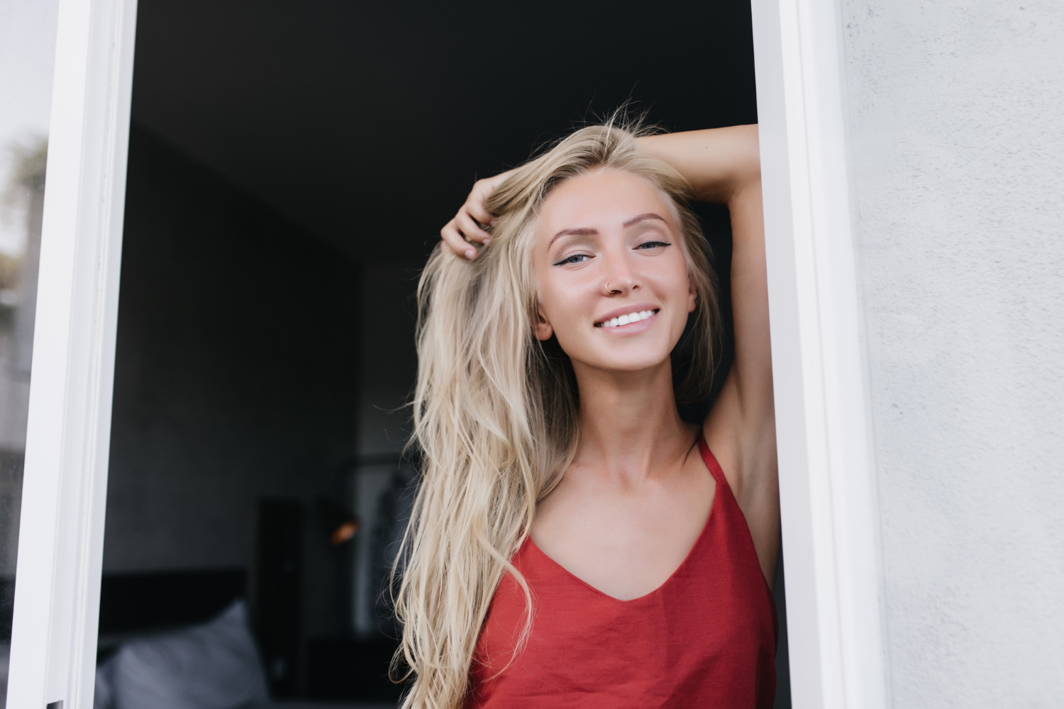 Eine lächelnde Frau, die an der Tür steht | Quelle: Freepik