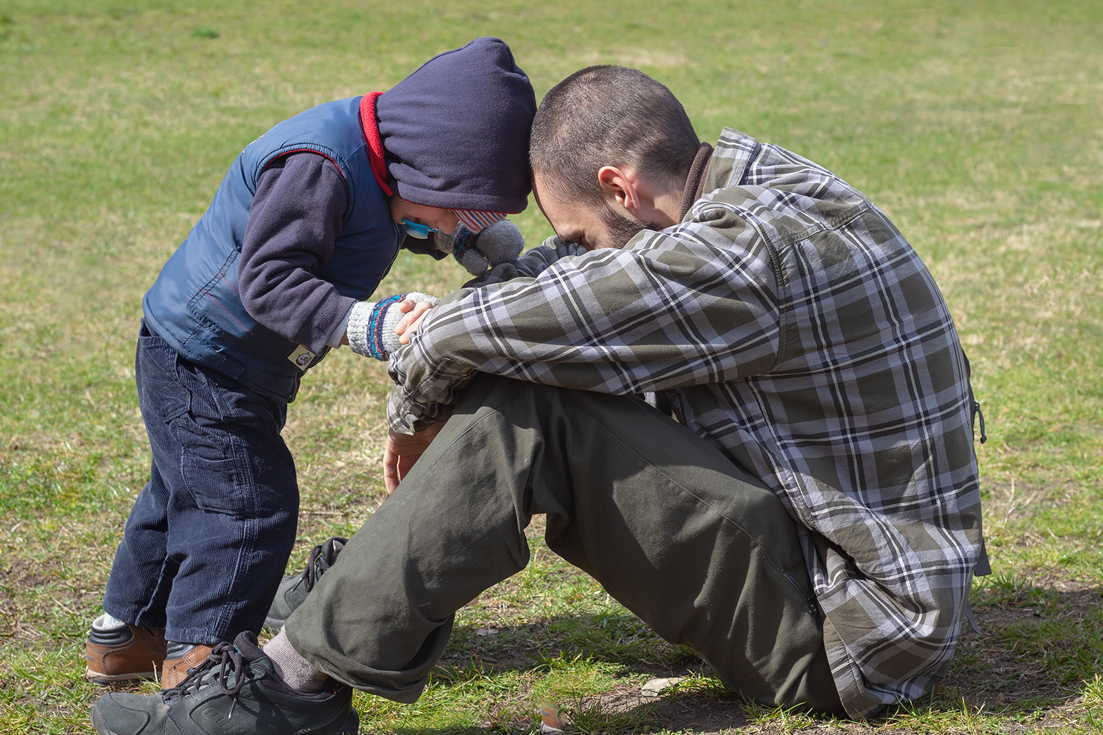 Ein Vater und sein Sohn sitzen auf einer Wiese | Quelle: Flickr