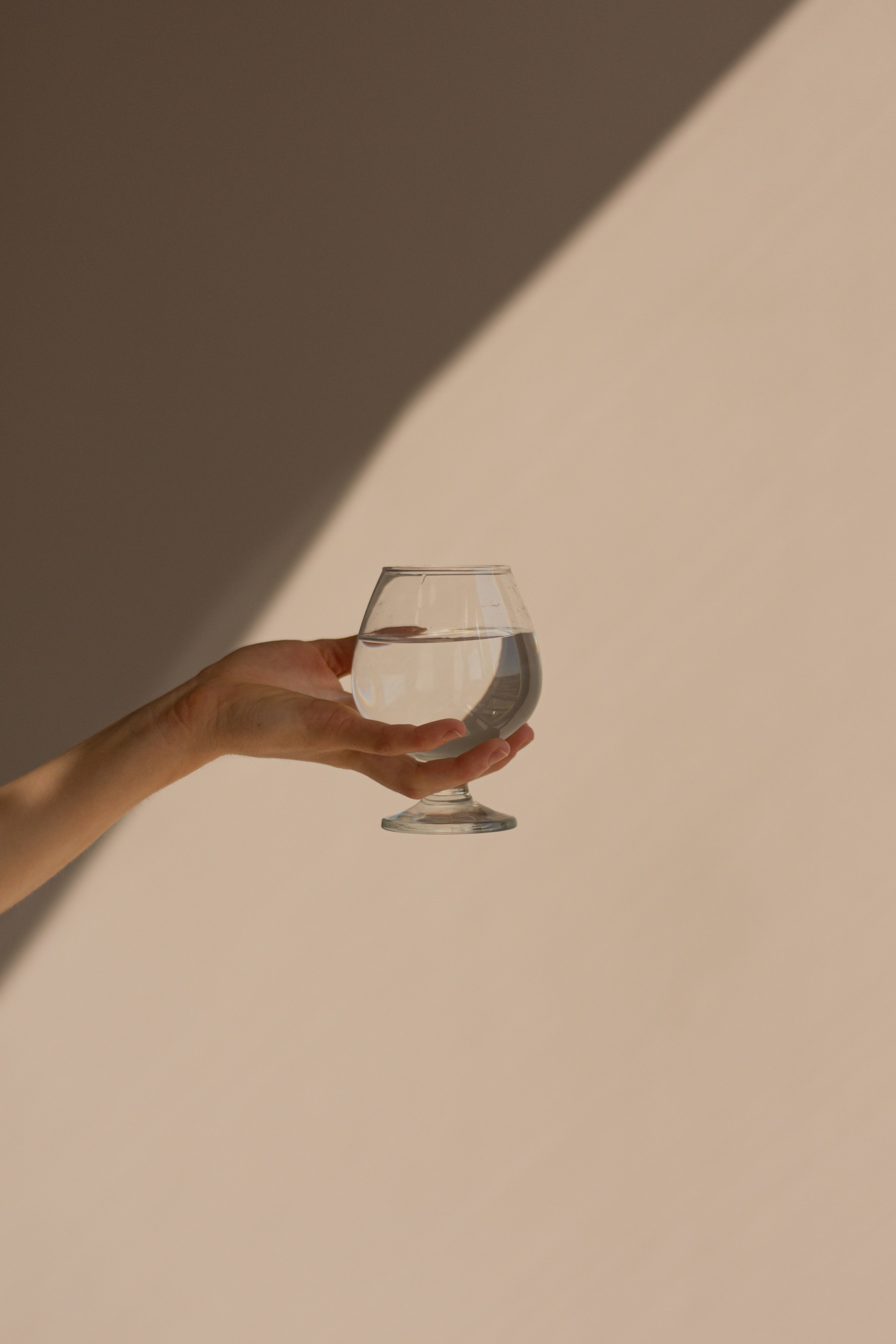 Eine Person erhebt ihr Glas | Quelle: Unsplash
