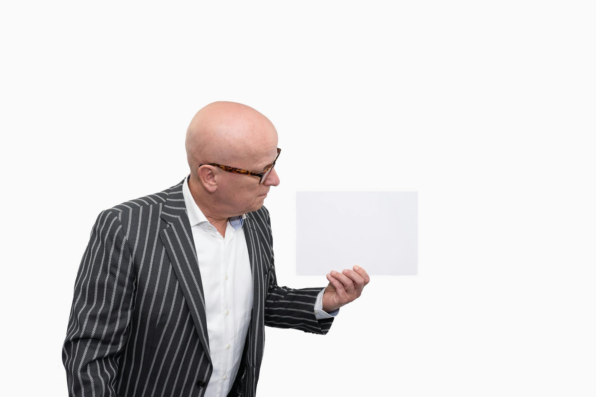 Ein älterer Mann hält ein Blatt Papier | Quelle: Pexels