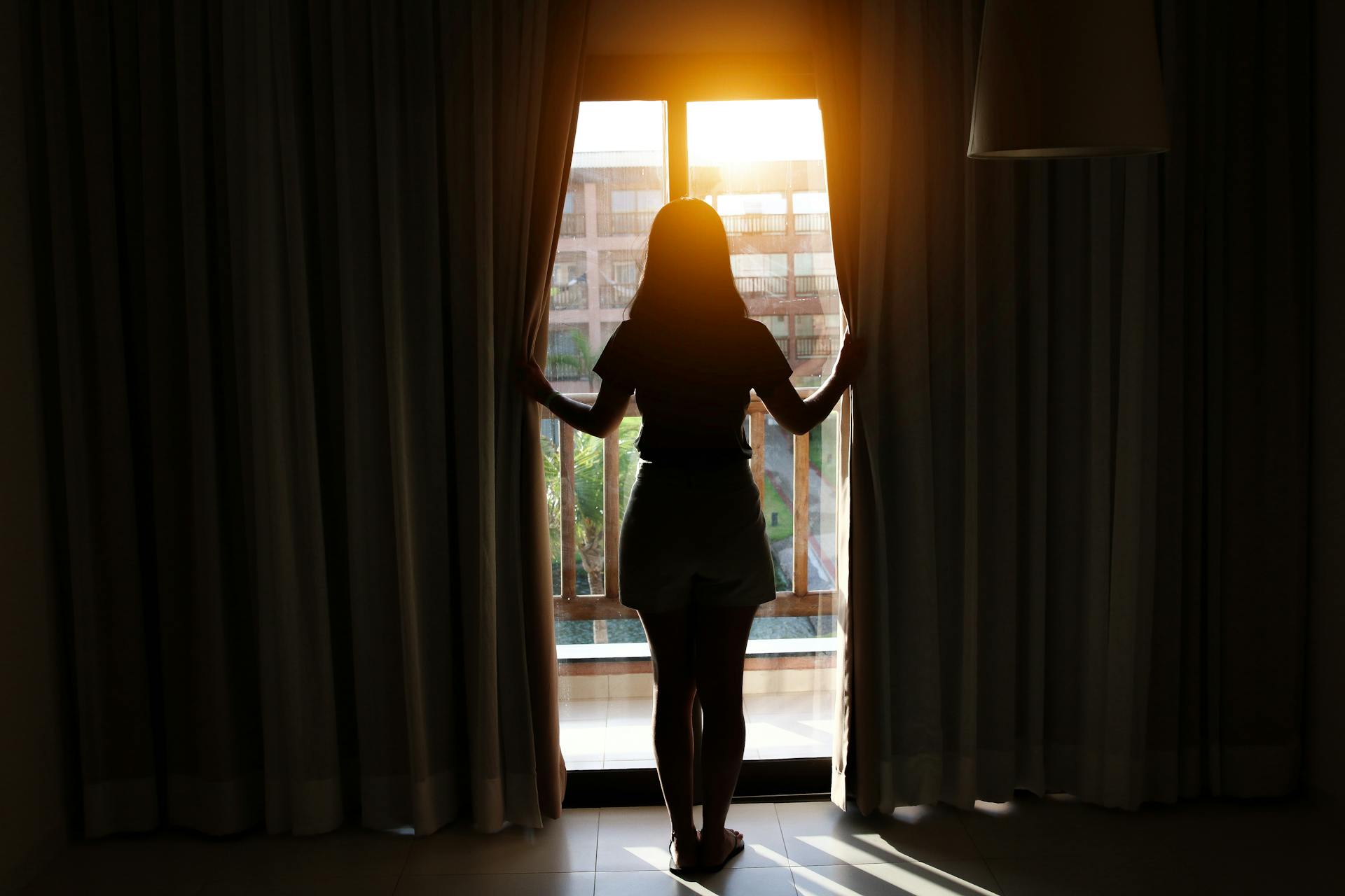 Eine junge Frau steht neben dem Fenster | Quelle: Pexels