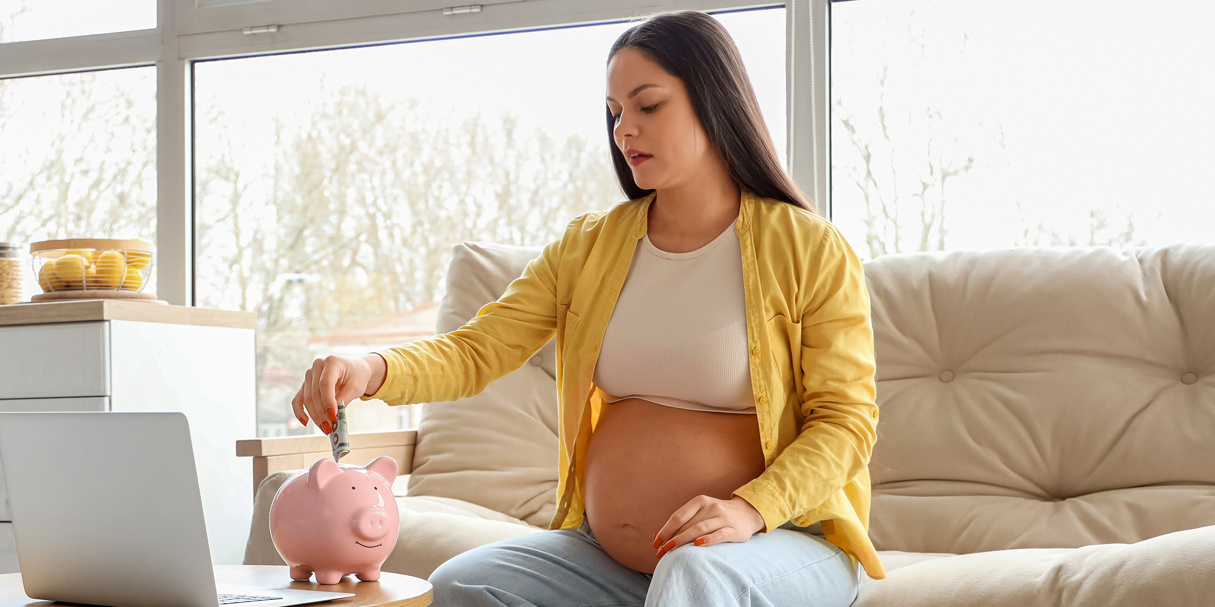 Eine schwangere Frau spart Geld in einem Sparschwein | Quelle: Shutterstock