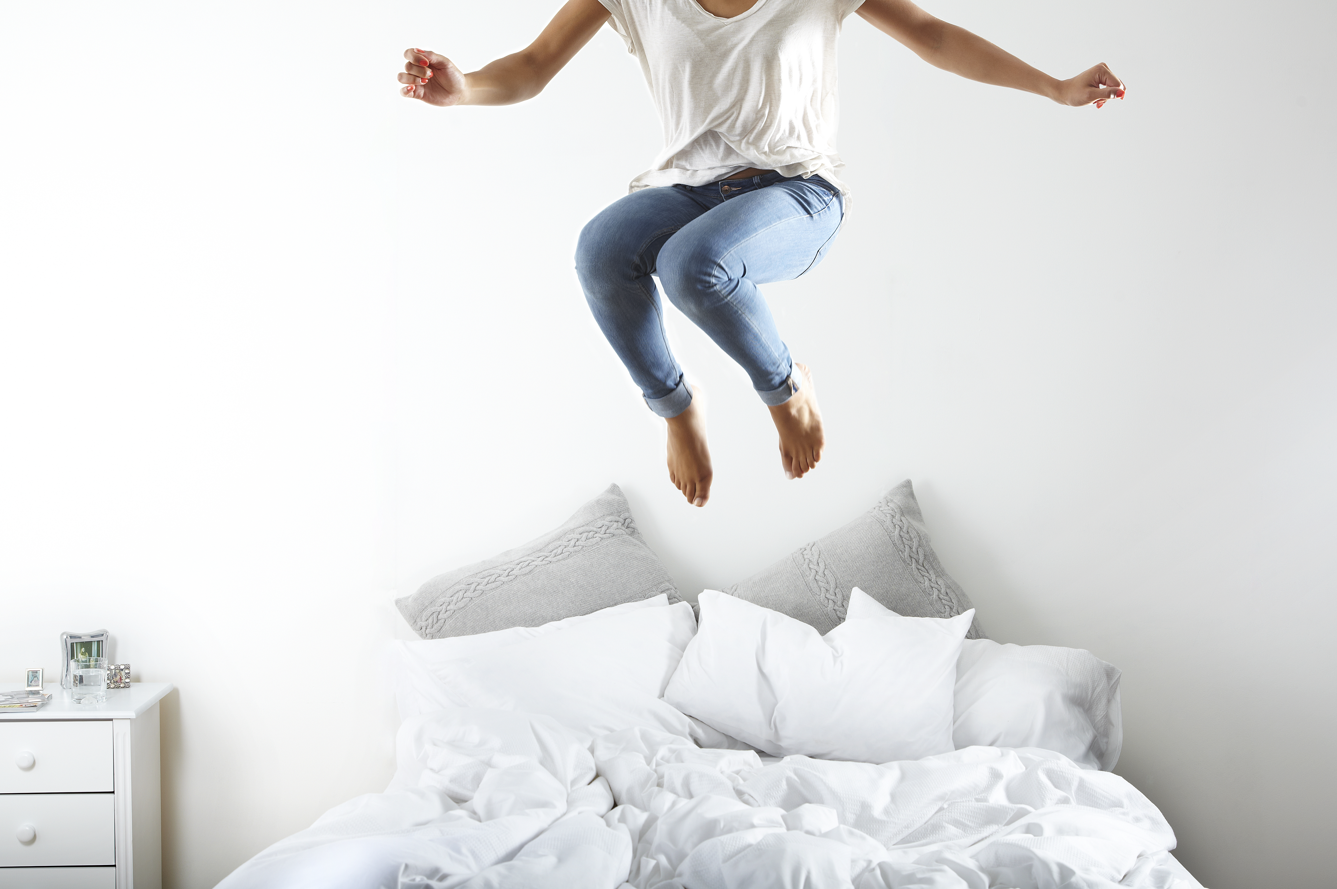 Porträt einer Frau, die auf das Bett springt | Quelle: Getty Images