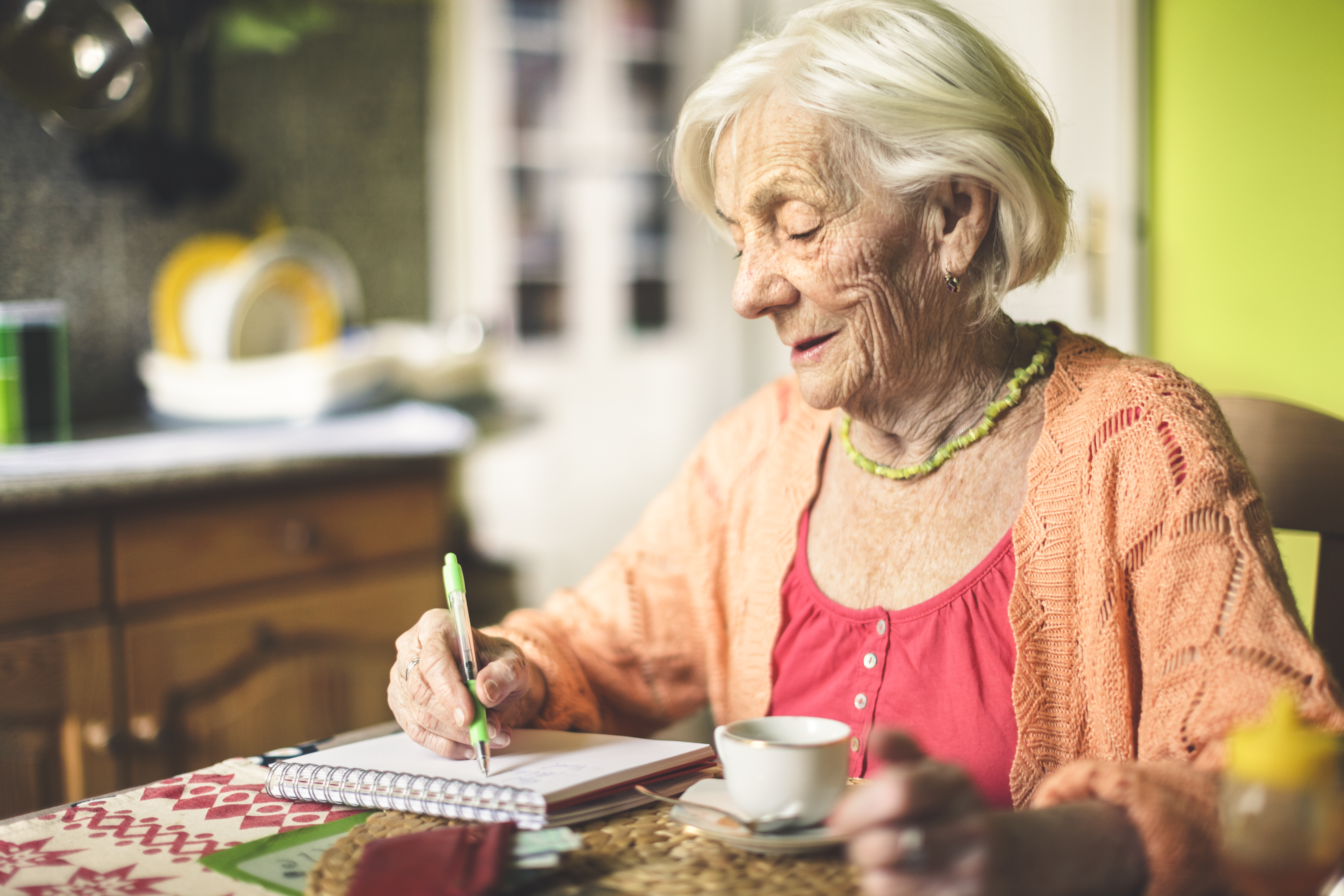 Ältere Frau, die in ihrer Küche ihre Finanzen berechnet | Quelle: Getty Images