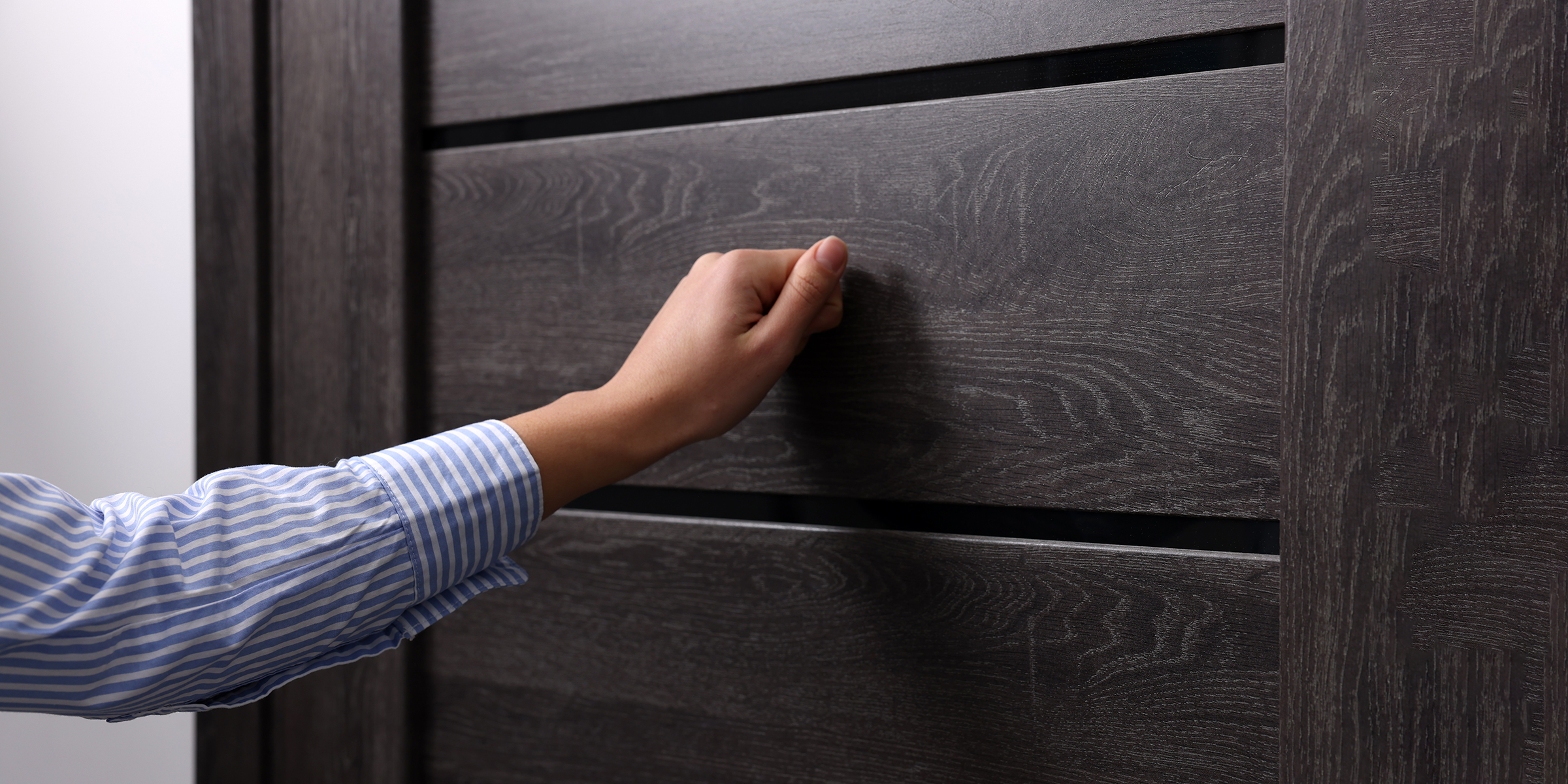 Eine Frau klopft an eine Haustür | Quelle: Shutterstock