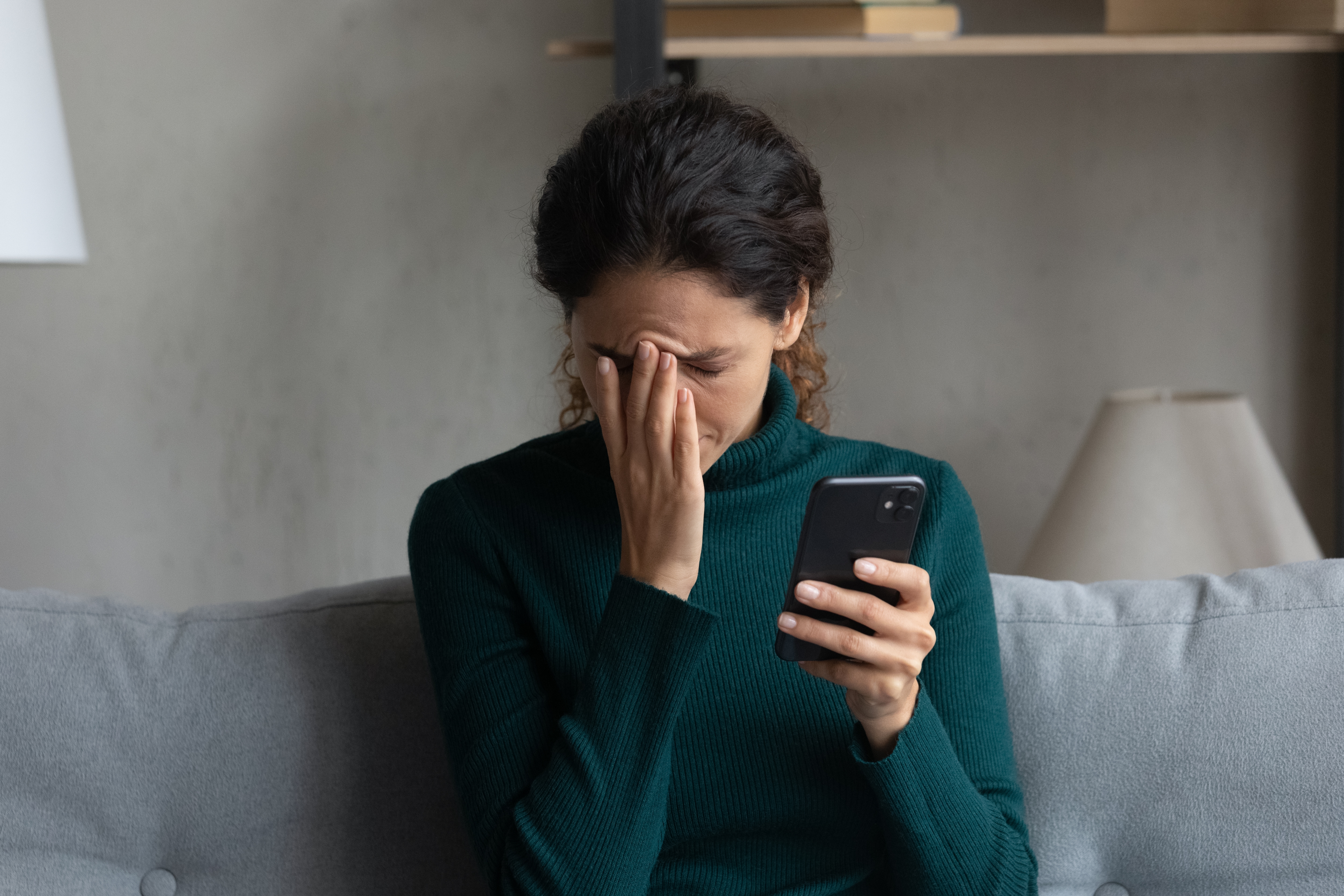 Eine verzweifelte Frau, die ihr Telefon hält | Quelle: Shutterstock