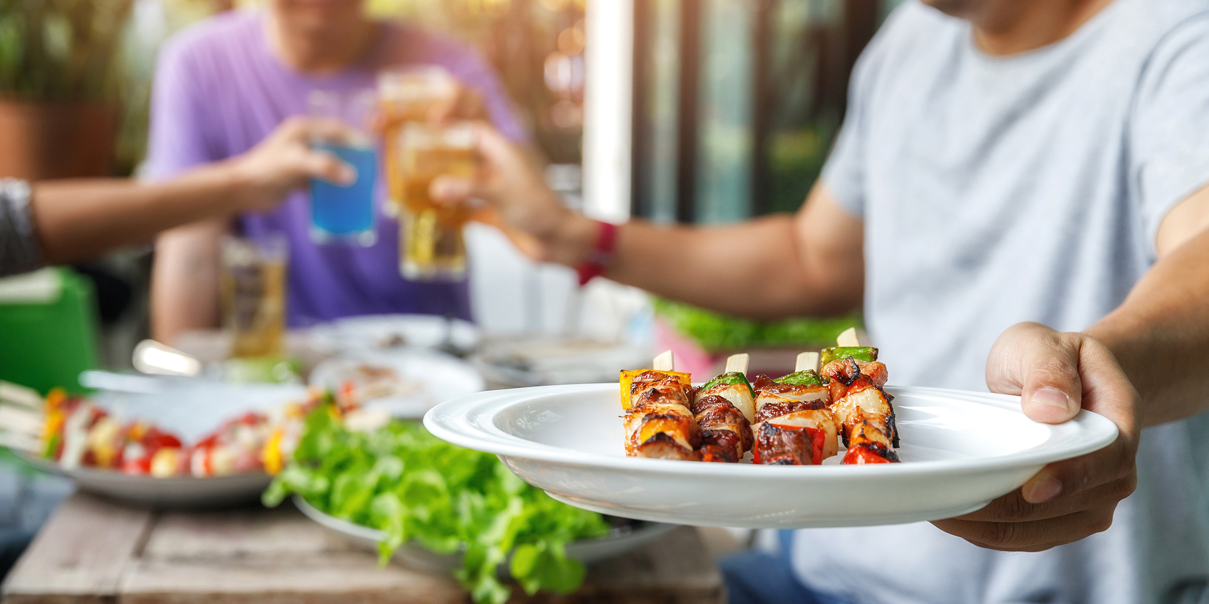 Ein Mann hält einen Grillteller auf einer Party | Quelle: Shutterstock